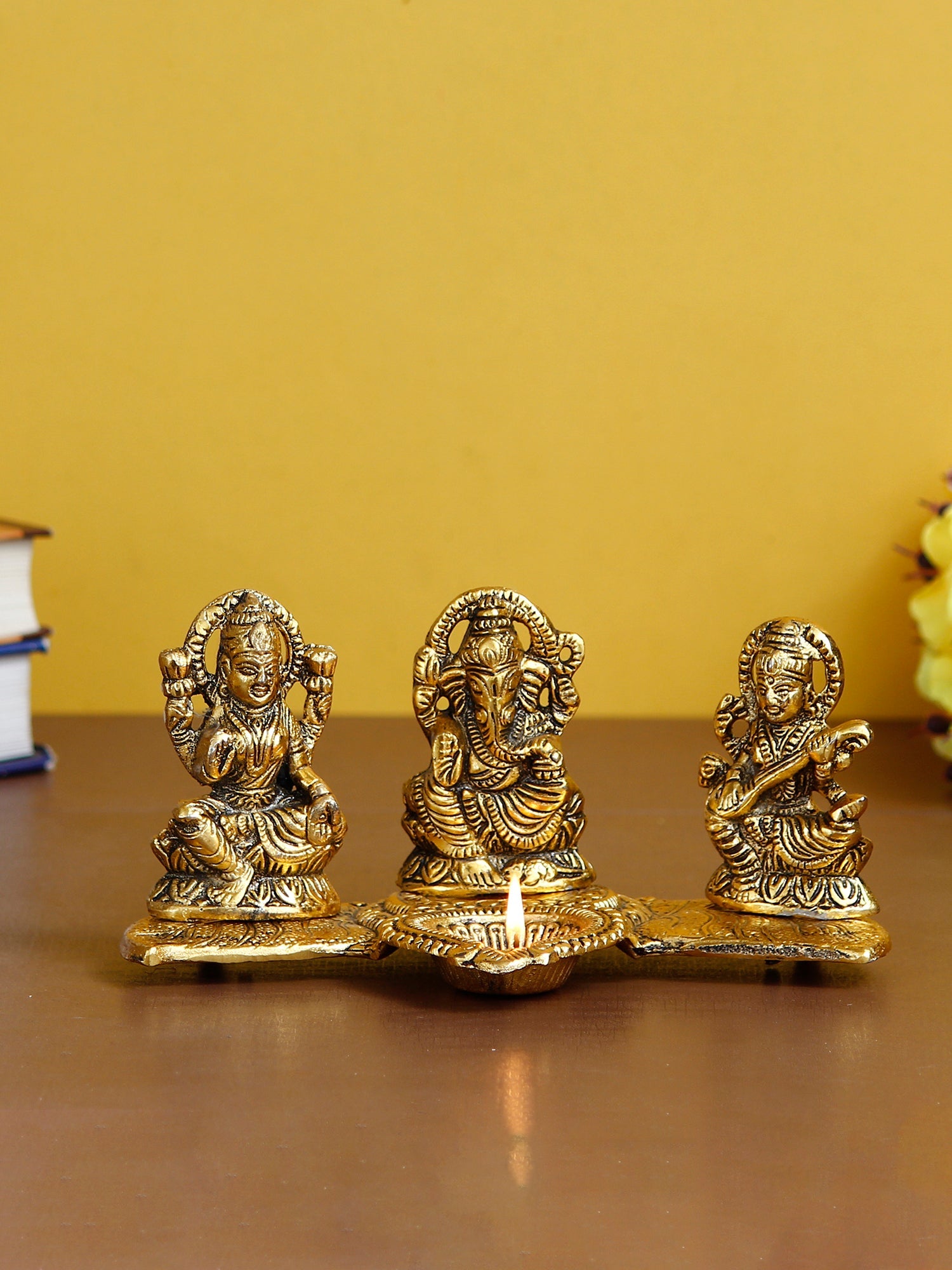 Gold Metal Handcrafted Laxmi Ganesha Saraswati Idols with Diya on Leaf Chowki Kafalo