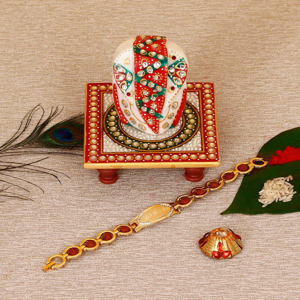 Designer Bracelet Religious Rakhi with Lord Ganesha on Kundan Studded Marble Chowki and Roli Tikka Matki Kafalo
