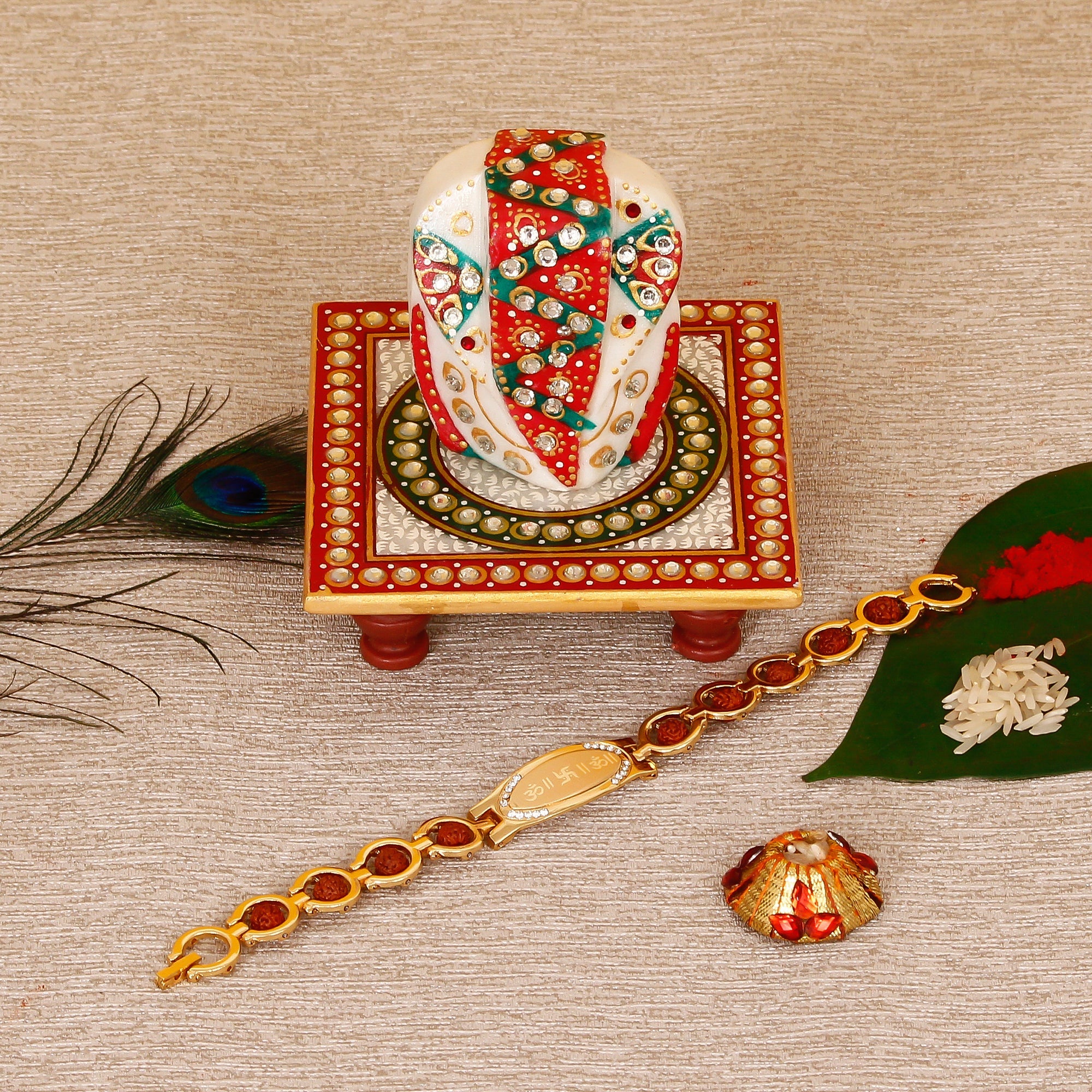 Designer Bracelet Religious Rakhi with Lord Ganesha on Kundan Studded Marble Chowki and Roli Tikka Matki Kafalo