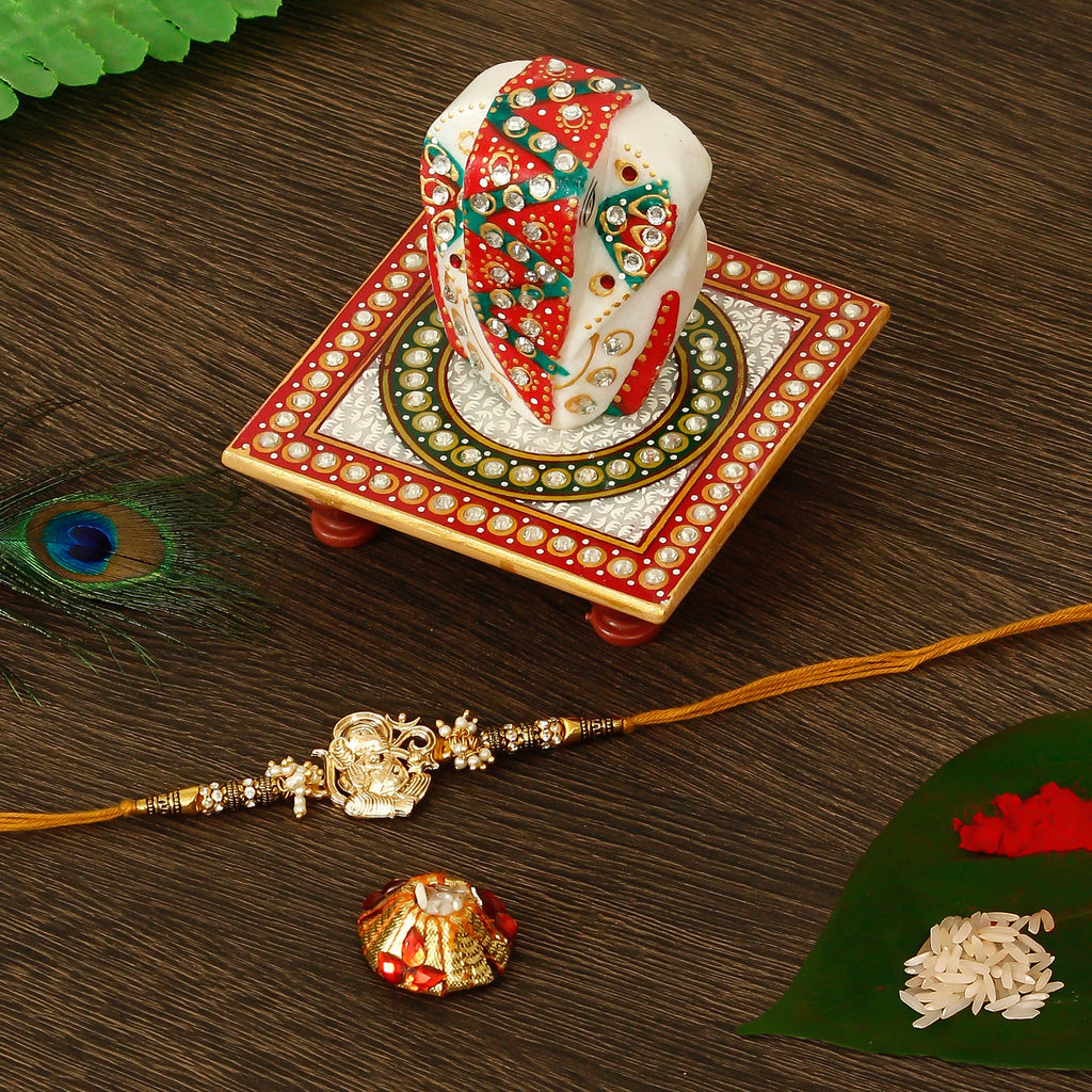 Designer Ganesha Rakhi with Lord Ganesha on Kundan Studded Marble Chowki and Roli Tikka Matki Kafalo