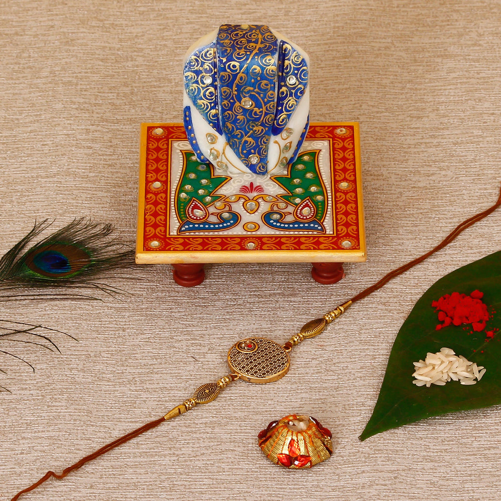 Designer Rakhi with Lord Ganesha on Marble Chowki and Roli Tikka Matki Kafalo