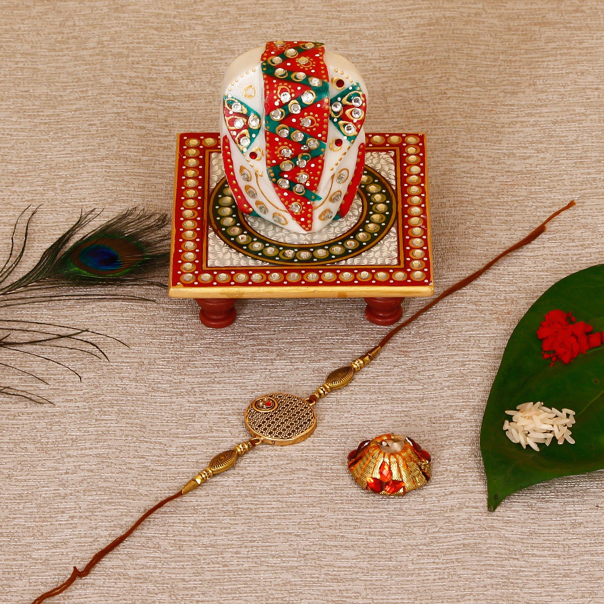 Designer Rakhi with Lord Ganesha on Kundan Studded Marble Chowki and Roli Tikka Matki Kafalo
