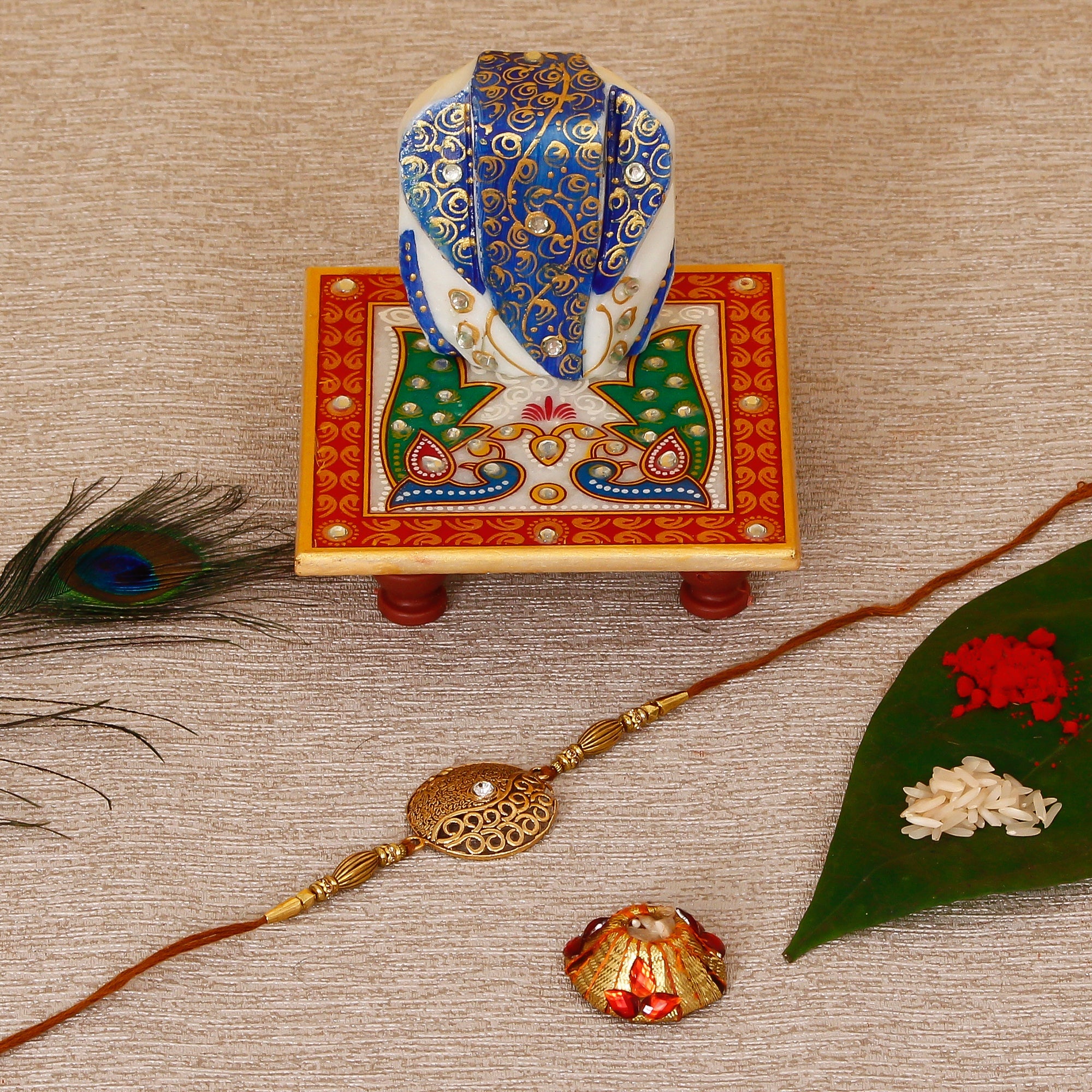 Designer Rakhi with Lord Ganesha on Marble Chowki and Roli Tikka Matki Kafalo