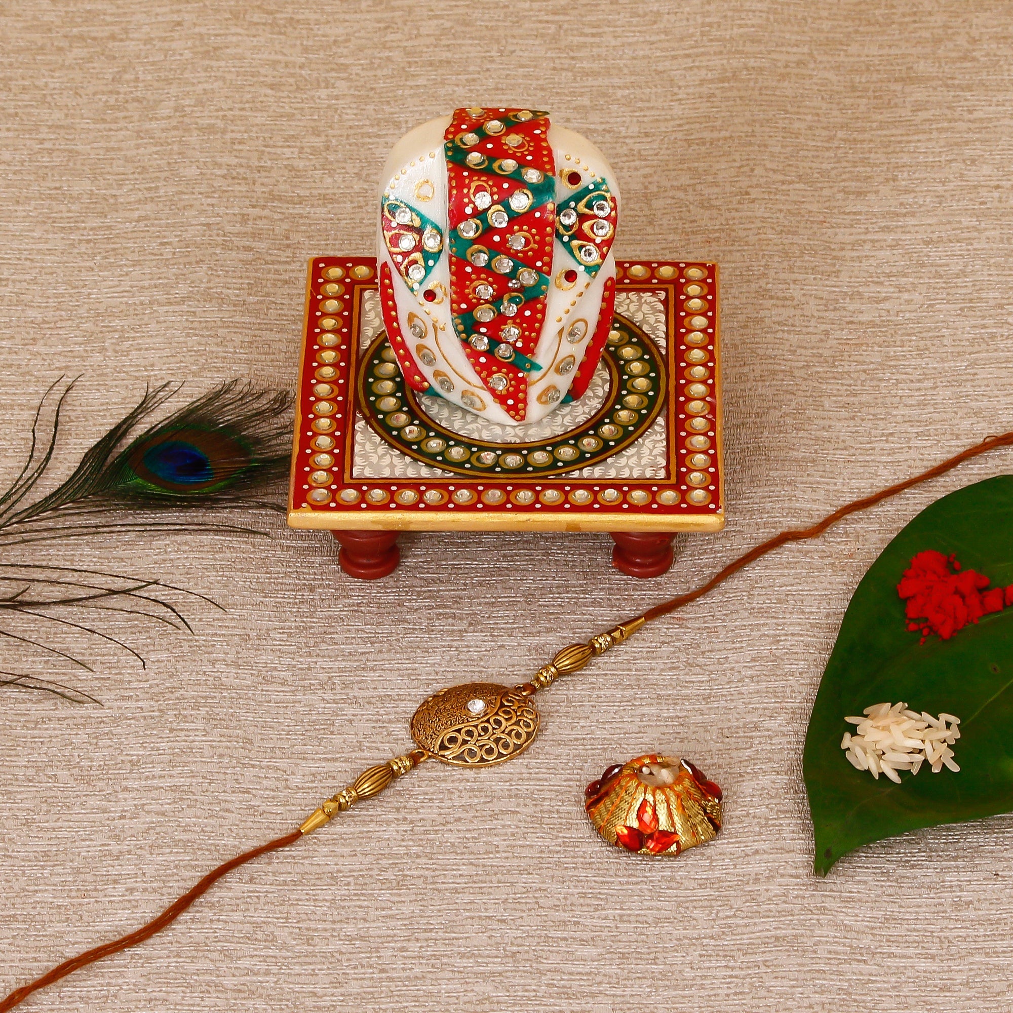 Designer Rakhi with Lord Ganesha on Kundan Studded Marble Chowki and Roli Tikka Matki Kafalo