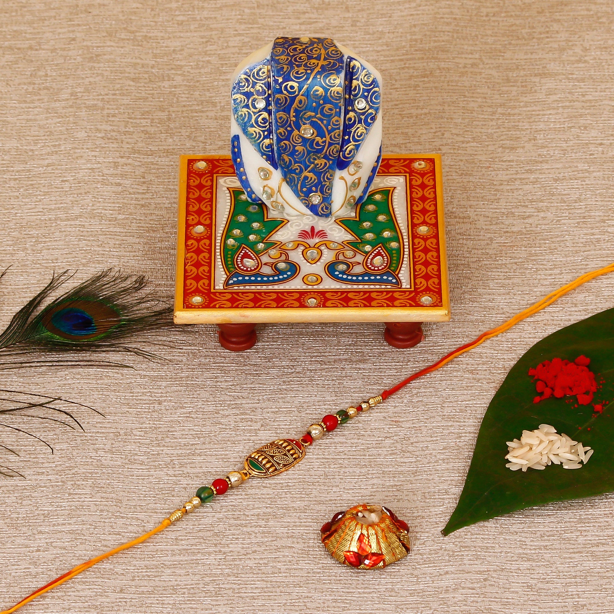 Designer Rakhi with Lord Ganesha on Marble Chowki and Roli Tikka Matki Kafalo