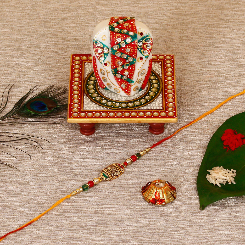 Designer Rakhi with Lord Ganesha on Kundan Studded Marble Chowki and Roli Tikka Matki Kafalo