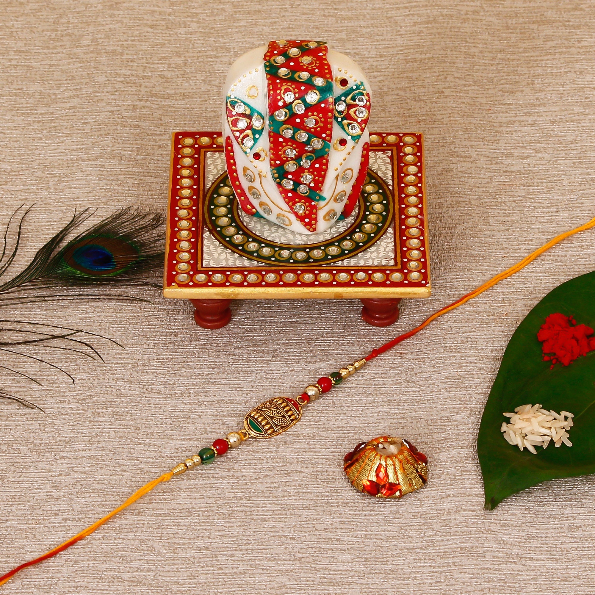 Designer Rakhi with Lord Ganesha on Kundan Studded Marble Chowki and Roli Tikka Matki Kafalo