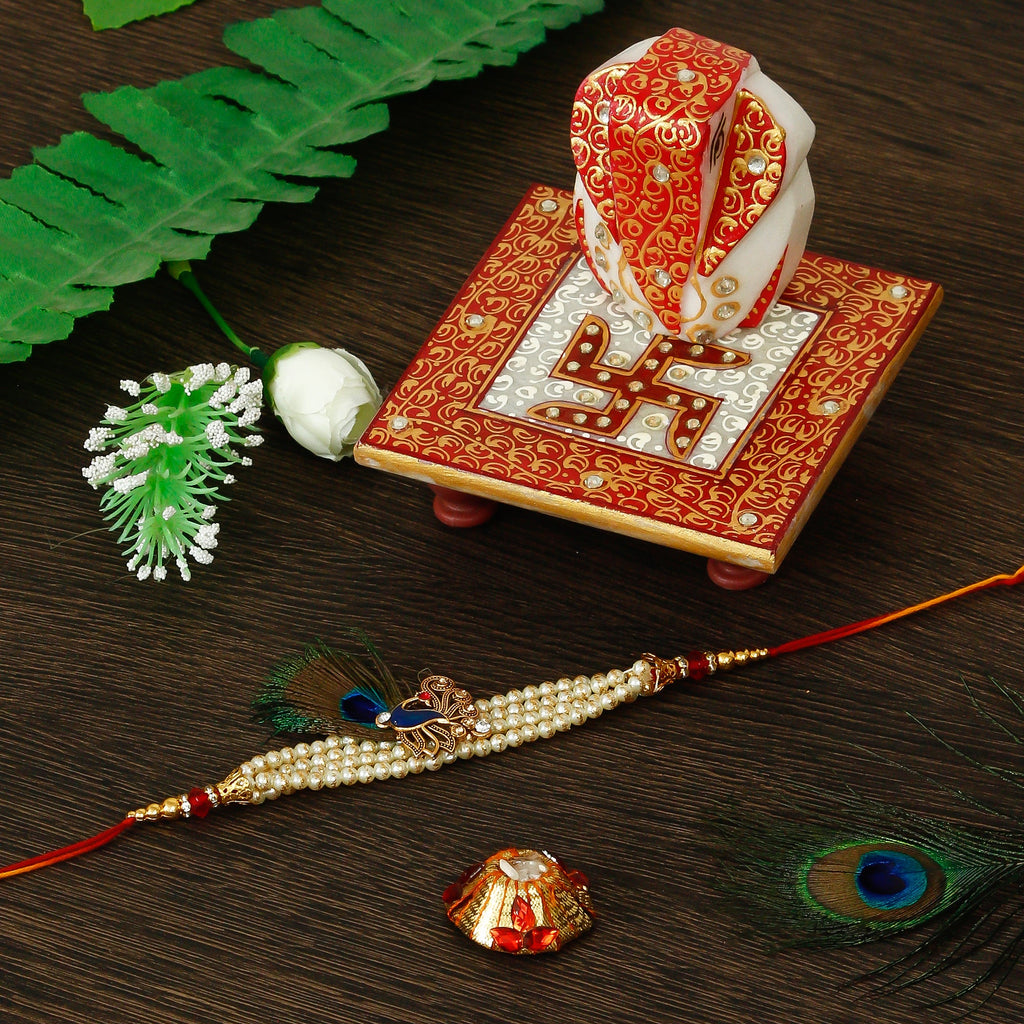 Designer Pearl Morpankh Rakhi with Ridhi Sidhi Marble chowki and Roli Tikka Matki Kafalo