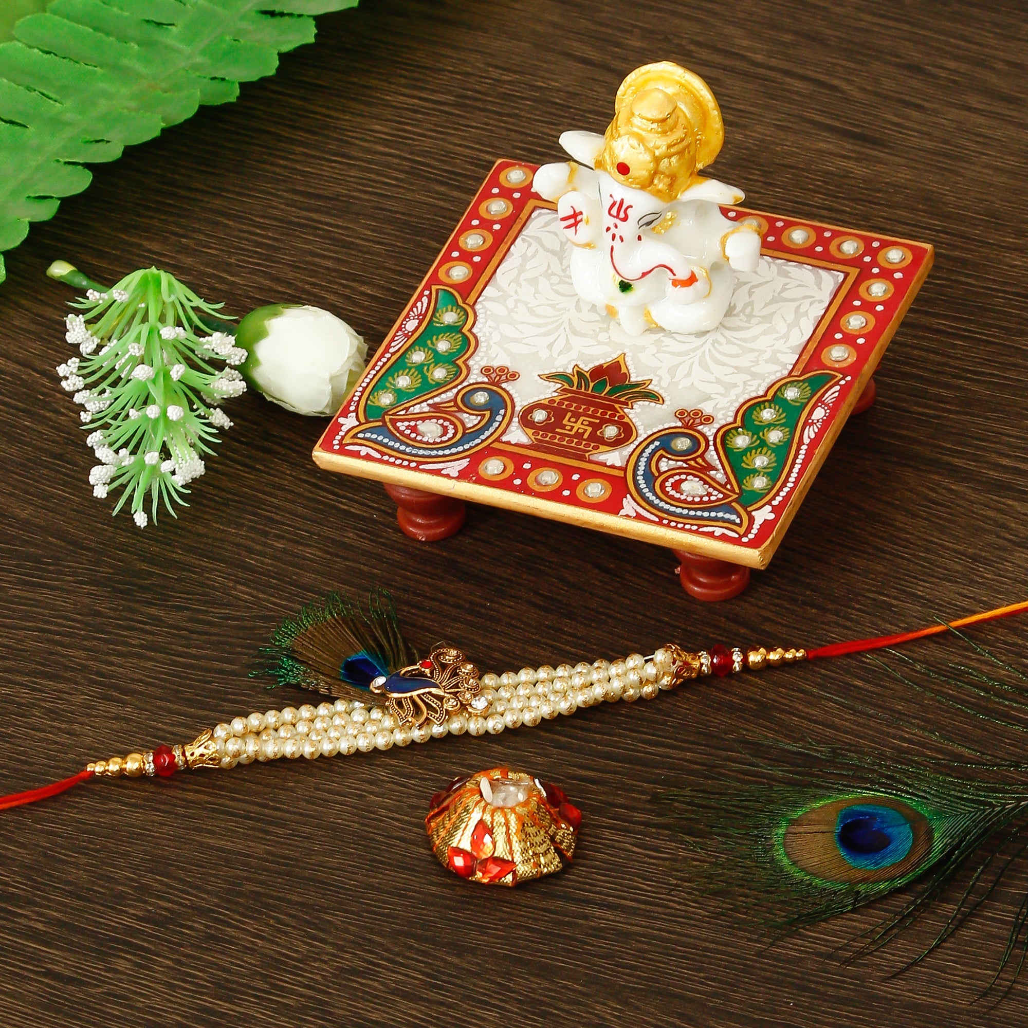 Designer Pearl Morpankh Rakhi with Lord Ganesha Marble Chowki and Roli Tikka Matki Kafalo
