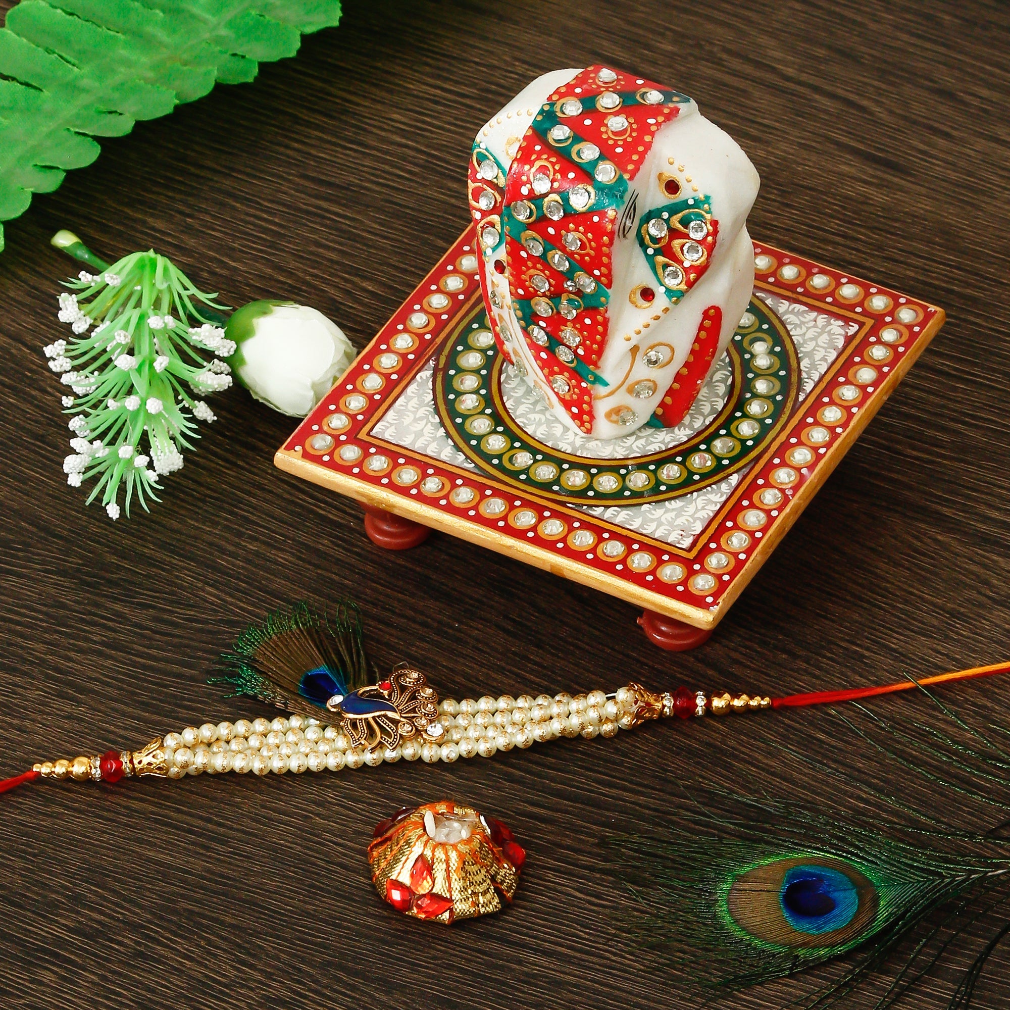 Designer Pearl Morpankh Rakhi with Lord Ganesha on Kundan Studded Marble Chowki and Roli Tikka Matki Kafalo