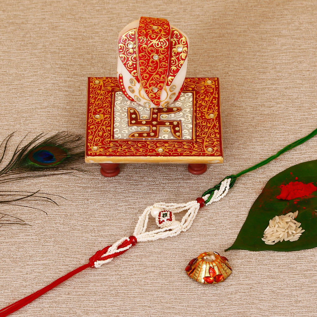 Designer Pearl Rakhi with Ridhi Sidhi Marble chowki and Roli Tikka Matki Kafalo