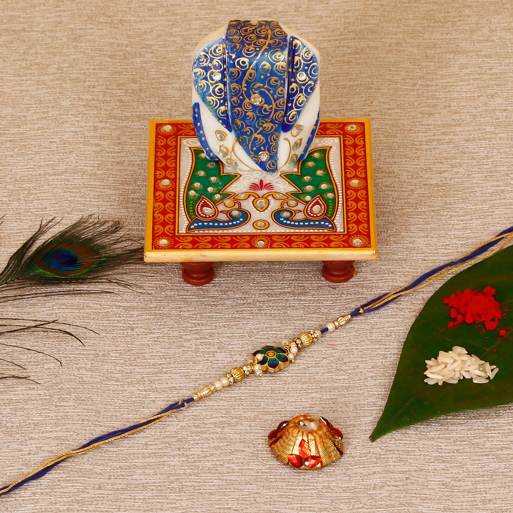 Designer Meenakari Rakhi with Lord Ganesha on Marble Chowki and Roli Tikka Matki Kafalo