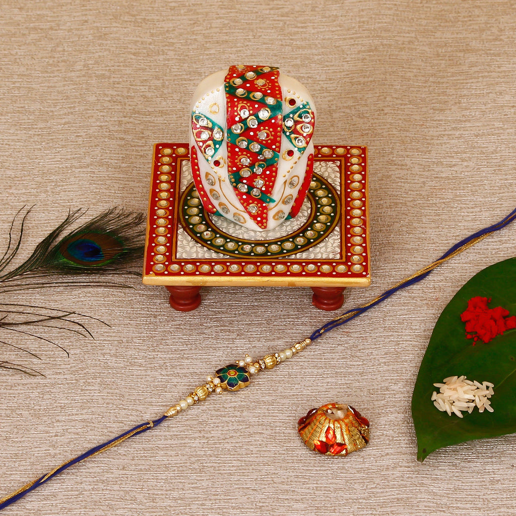 Designer Meenakari Rakhi with Lord Ganesha on Kundan Studded Marble Chowki and Roli Tikka Matki Kafalo