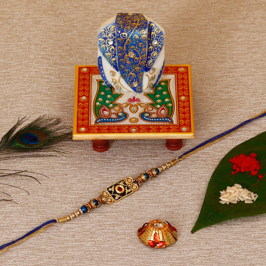 Designer Meenakari Rakhi with Lord Ganesha on Marble Chowki and Roli Tikka Matki Kafalo