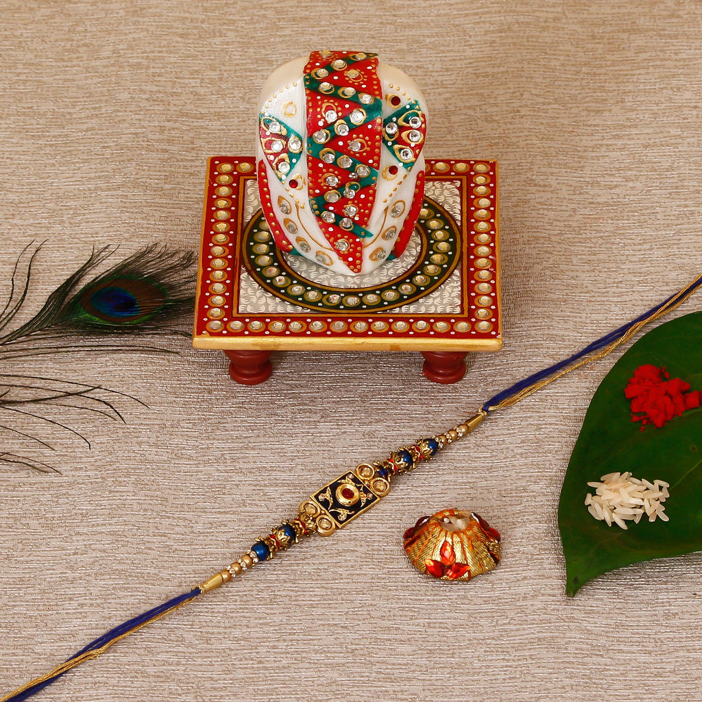 Designer Meenakari Rakhi with Lord Ganesha on Kundan Studded Marble Chowki and Roli Tikka Matki Kafalo