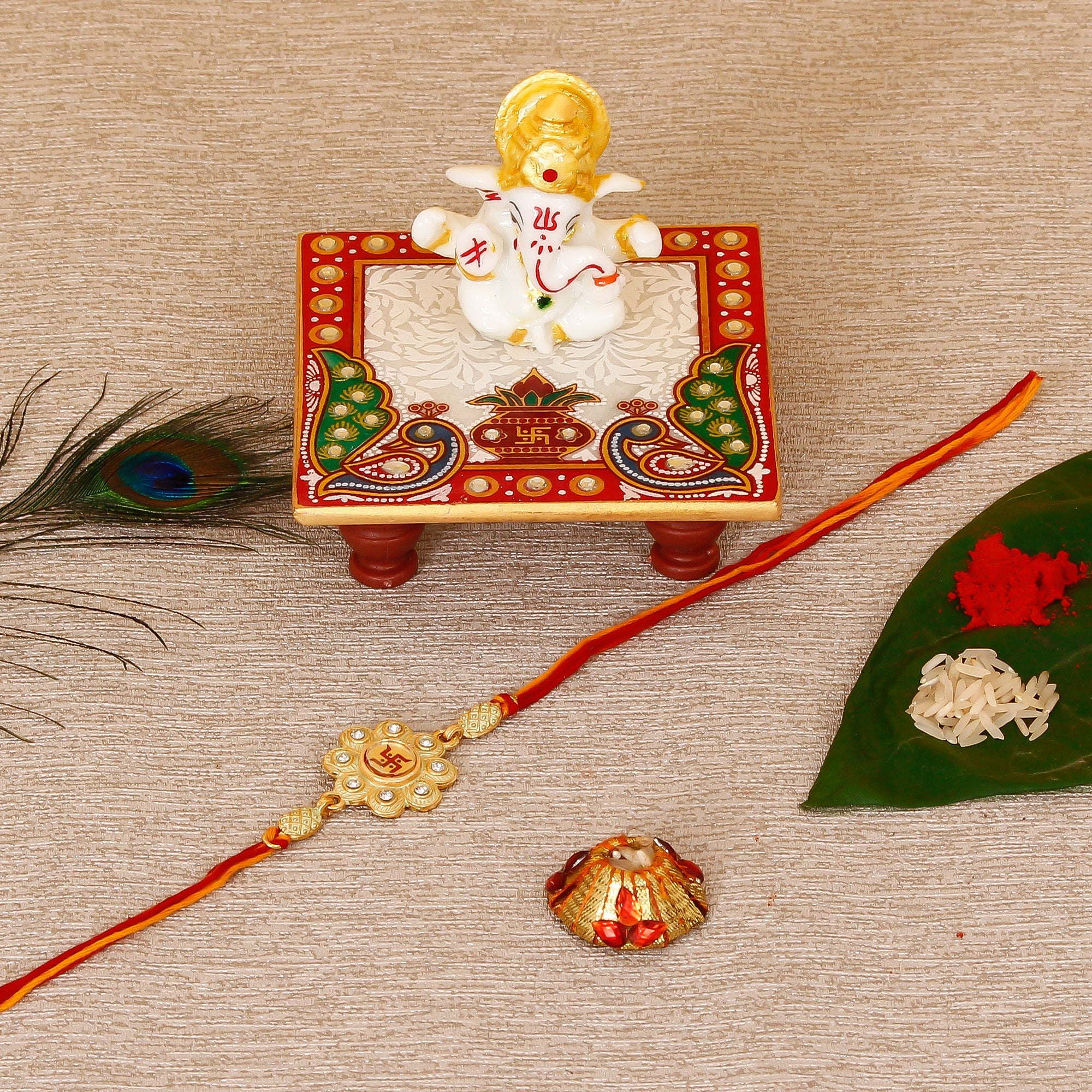 Designer Religious Swastik Rakhi with Lord Ganesha Marble Chowki and Roli Tikka Matki Kafalo
