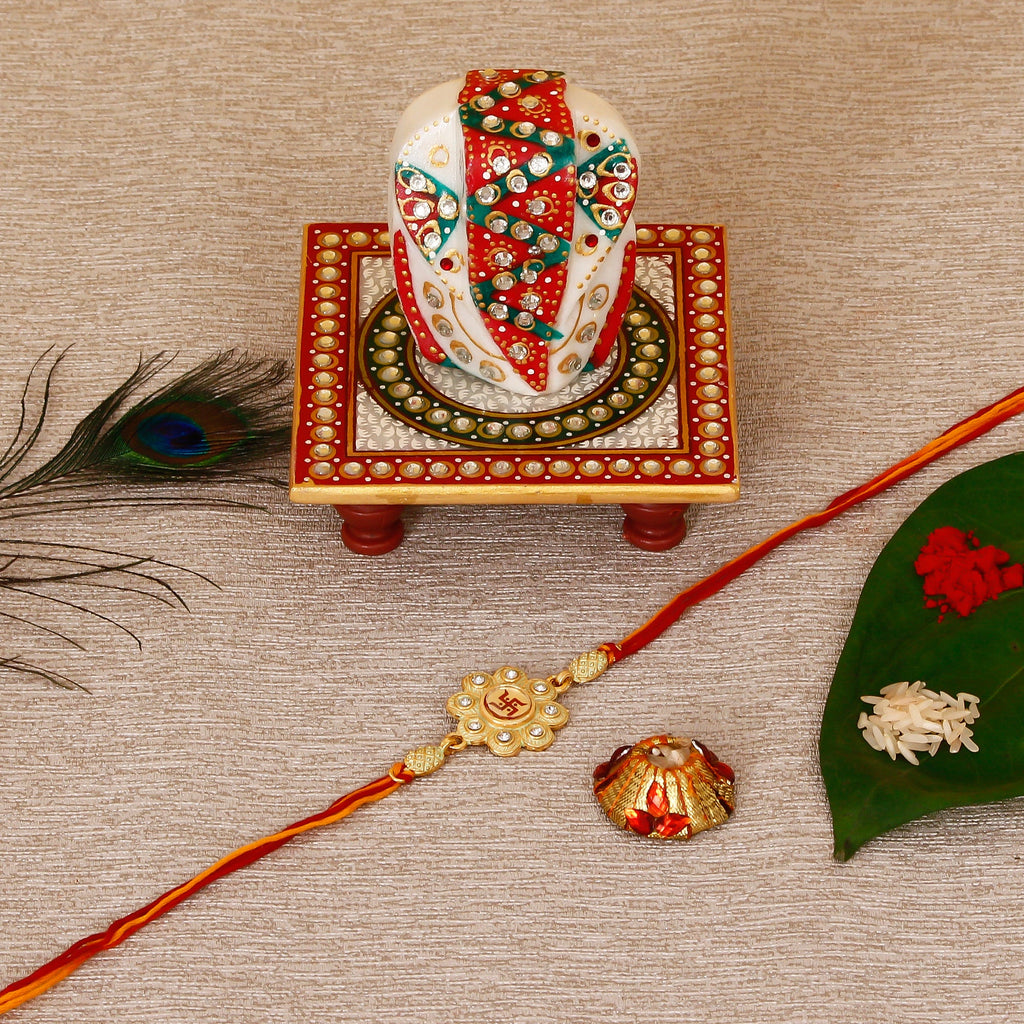 Designer Religious Swastik Rakhi with Lord Ganesha on Kundan Studded Marble Chowki and Roli Tikka Matki Kafalo