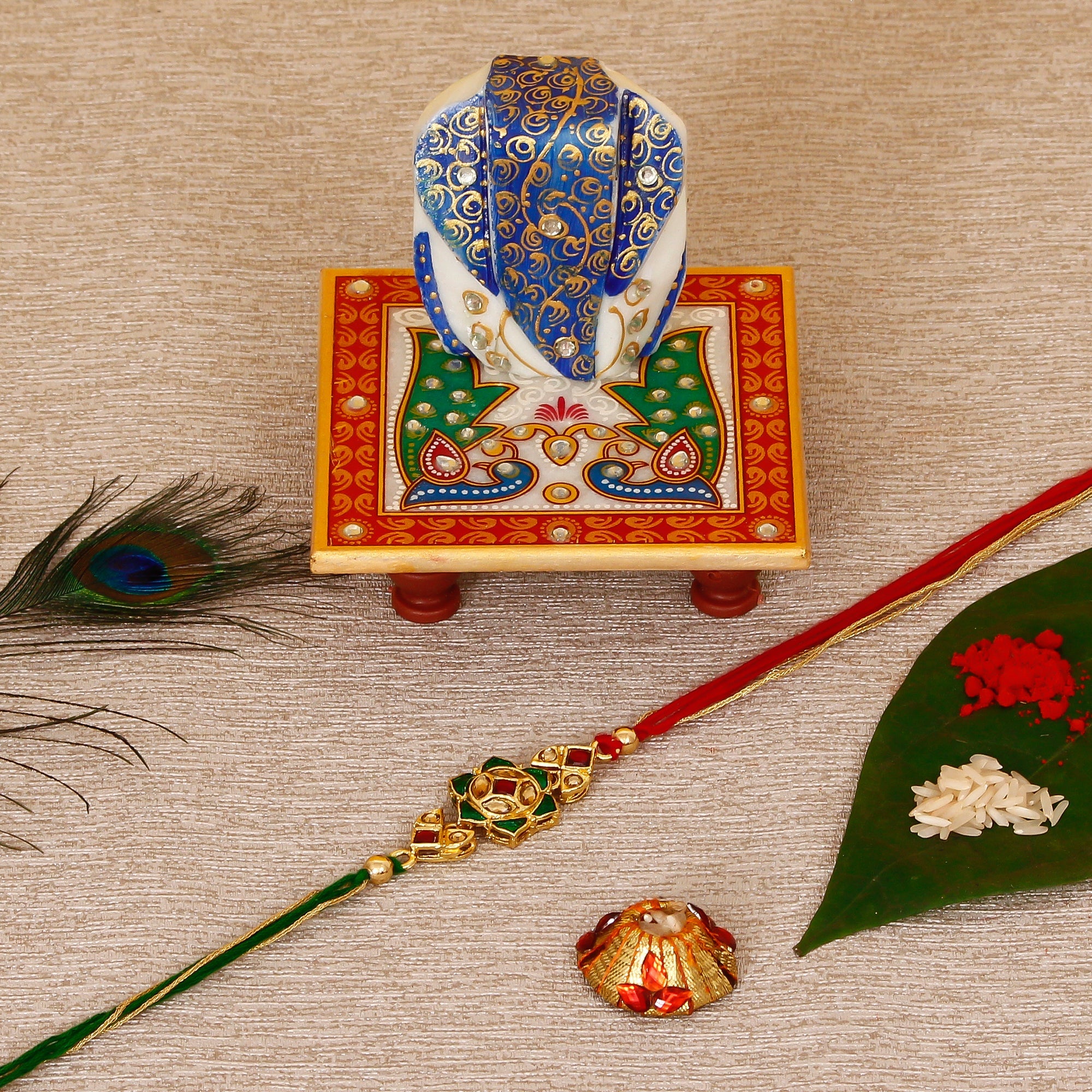 Designer Kundan Rakhi with Lord Ganesha on Marble Chowki and Roli Tikka Matki Kafalo