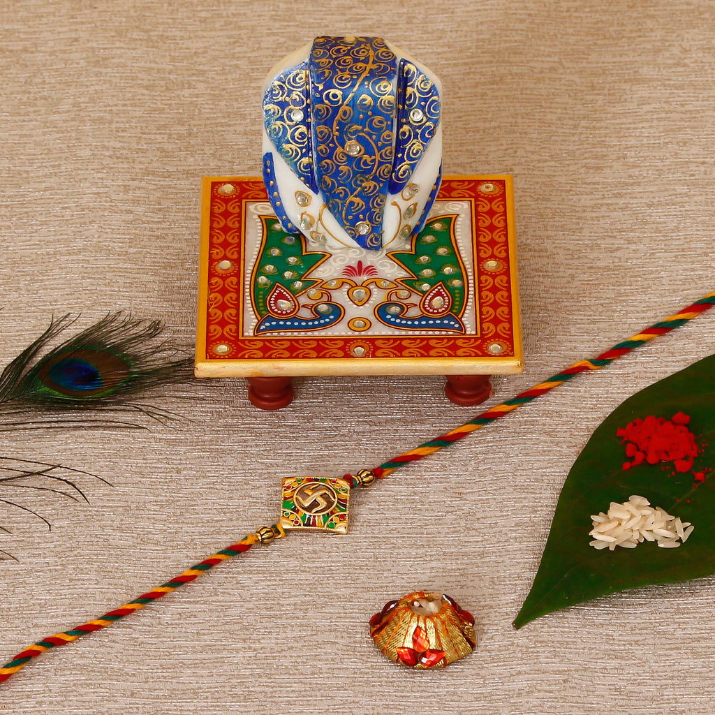 Designer Religious Swastik Rakhi with Lord Ganesha on Marble Chowki and Roli Tikka Matki Kafalo