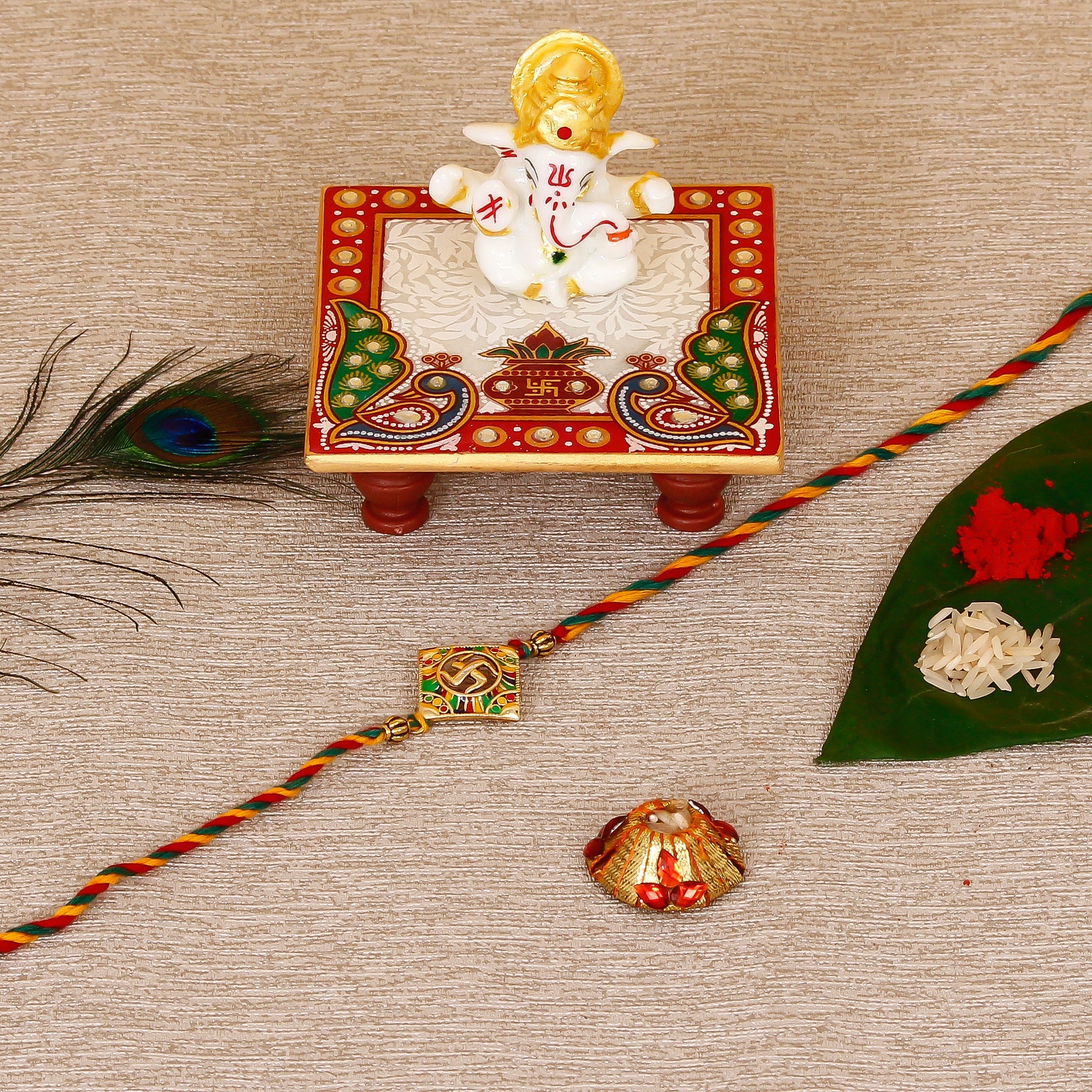 Designer Religious Swastik Rakhi with Lord Ganesha Marble Chowki and Roli Tikka Matki Kafalo