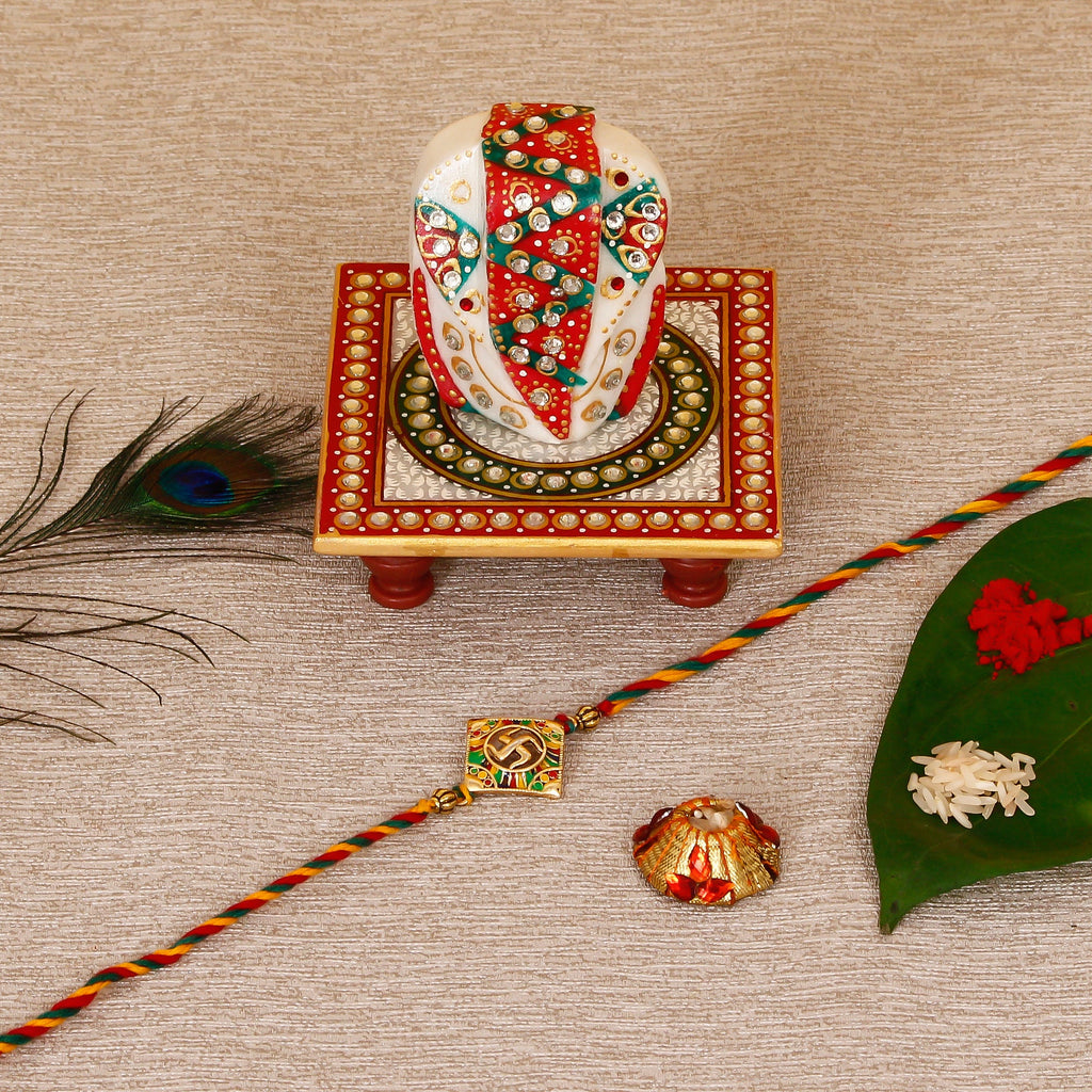 Designer Religious Swastik Rakhi with Lord Ganesha on Kundan Studded Marble Chowki and Roli Tikka Matki Kafalo