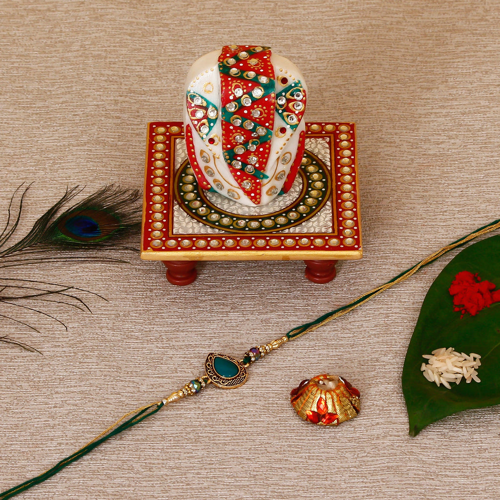 Designer Stone Rakhi with Lord Ganesha on Kundan Studded Marble Chowki and Roli Tikka Matki Kafalo
