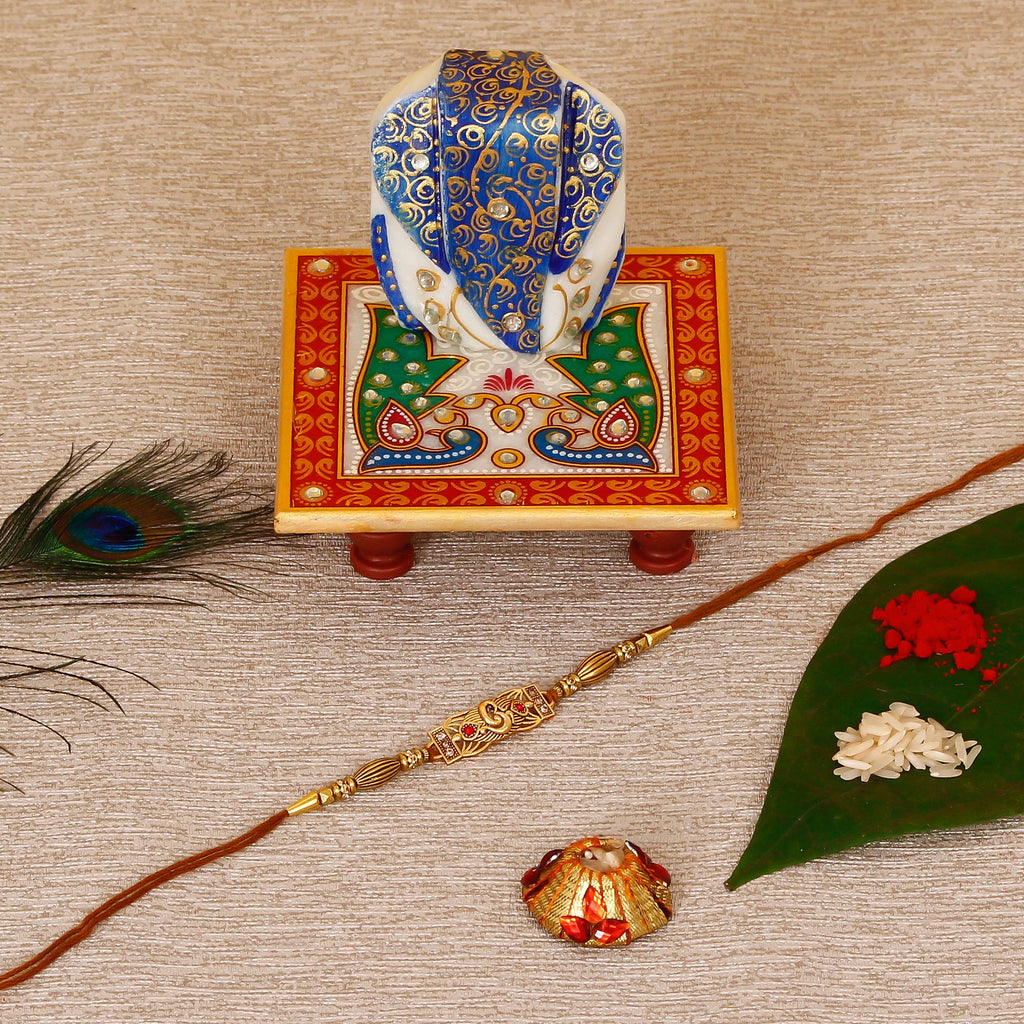 Designer Religious Rakhi with Lord Ganesha on Marble Chowki and Roli Tikka Matki Kafalo