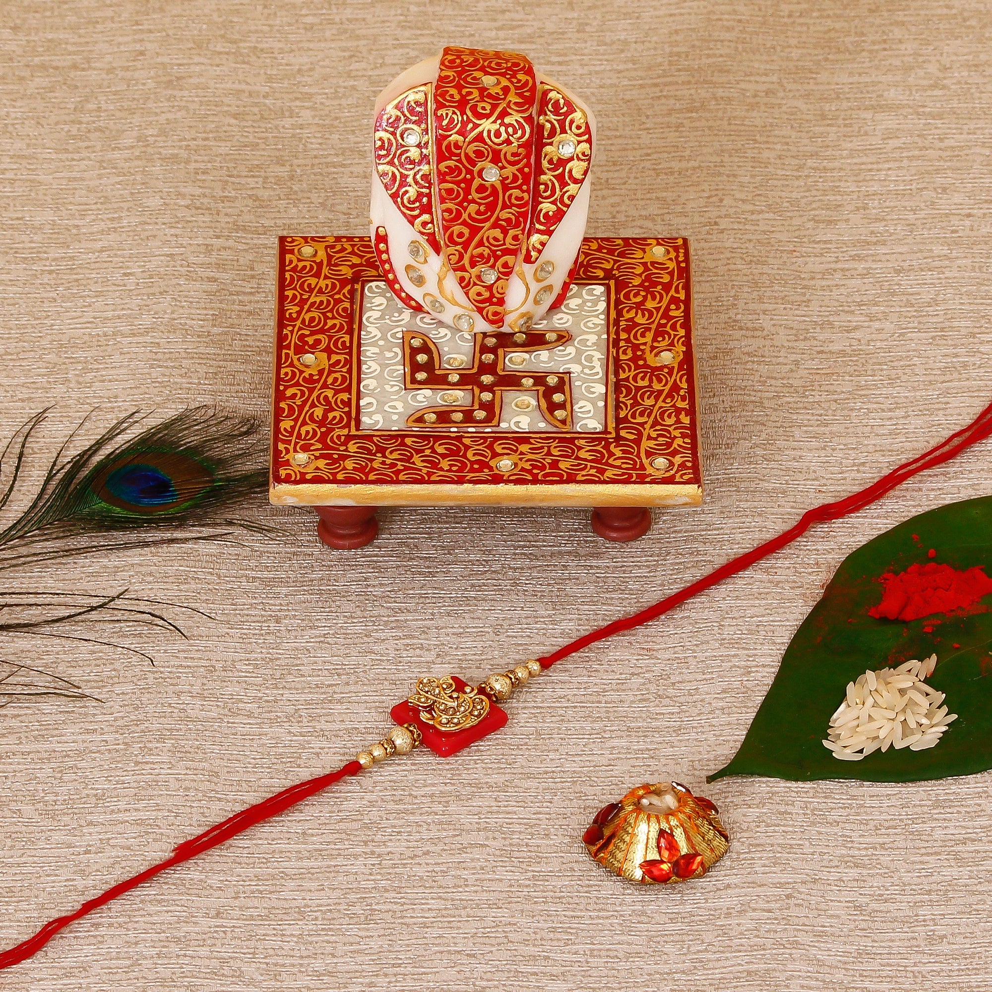 Designer Religious Ganesha Rakhi with Ridhi Sidhi Marble chowki and Roli Tikka Matki Kafalo