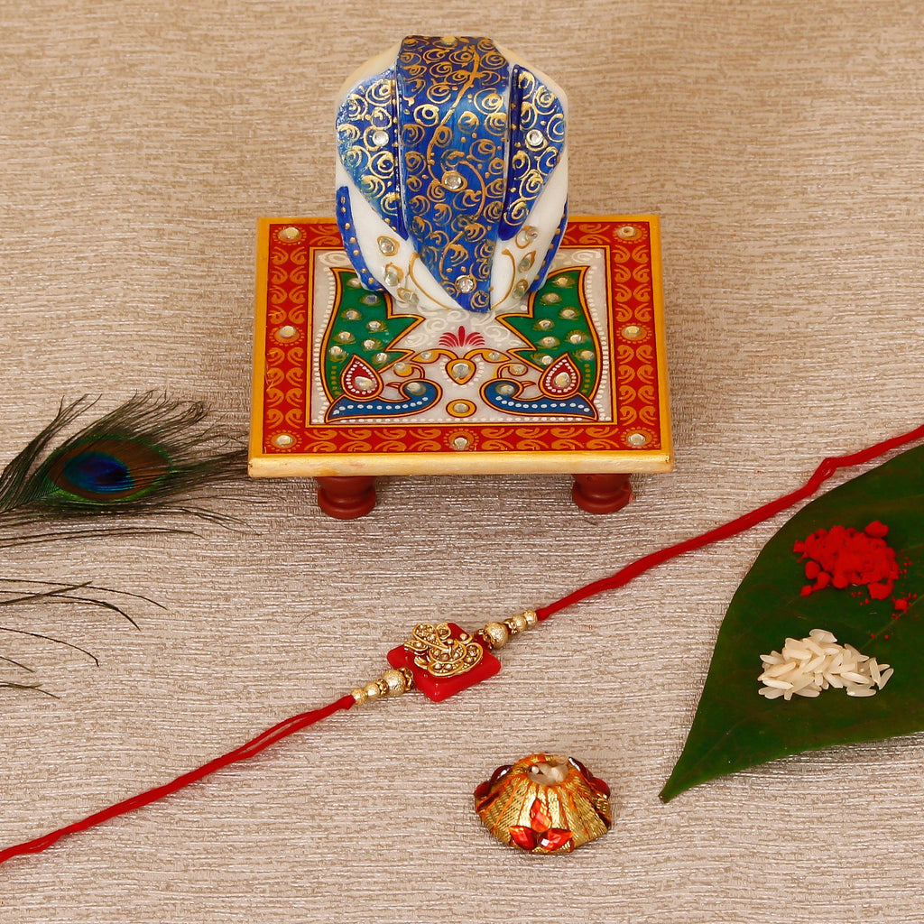 Designer Religious Ganesha Rakhi with Lord Ganesha on Marble Chowki and Roli Tikka Matki Kafalo