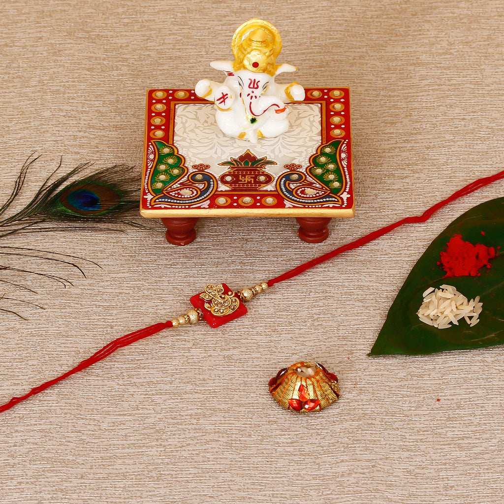 Designer Religious Ganesha Rakhi with Lord Ganesha Marble Chowki and Roli Tikka Matki Kafalo