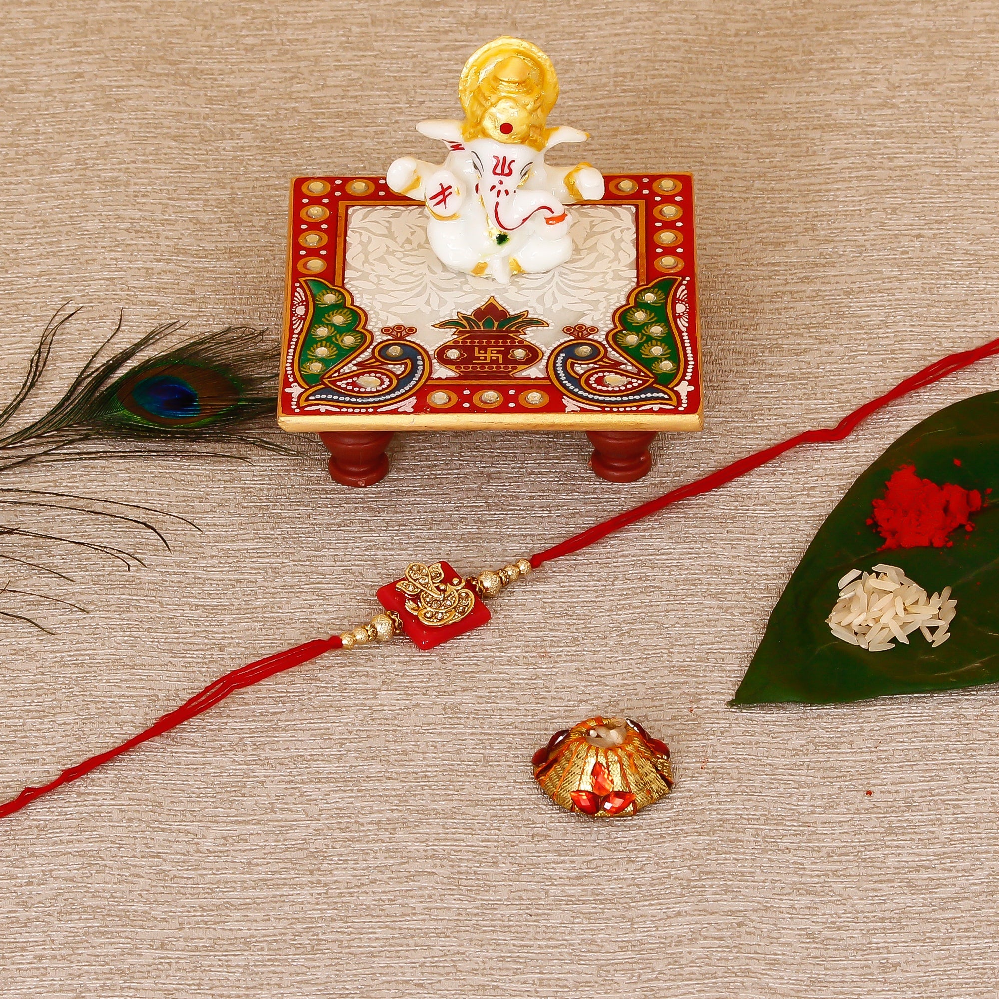 Designer Religious Ganesha Rakhi with Lord Ganesha Marble Chowki and Roli Tikka Matki Kafalo