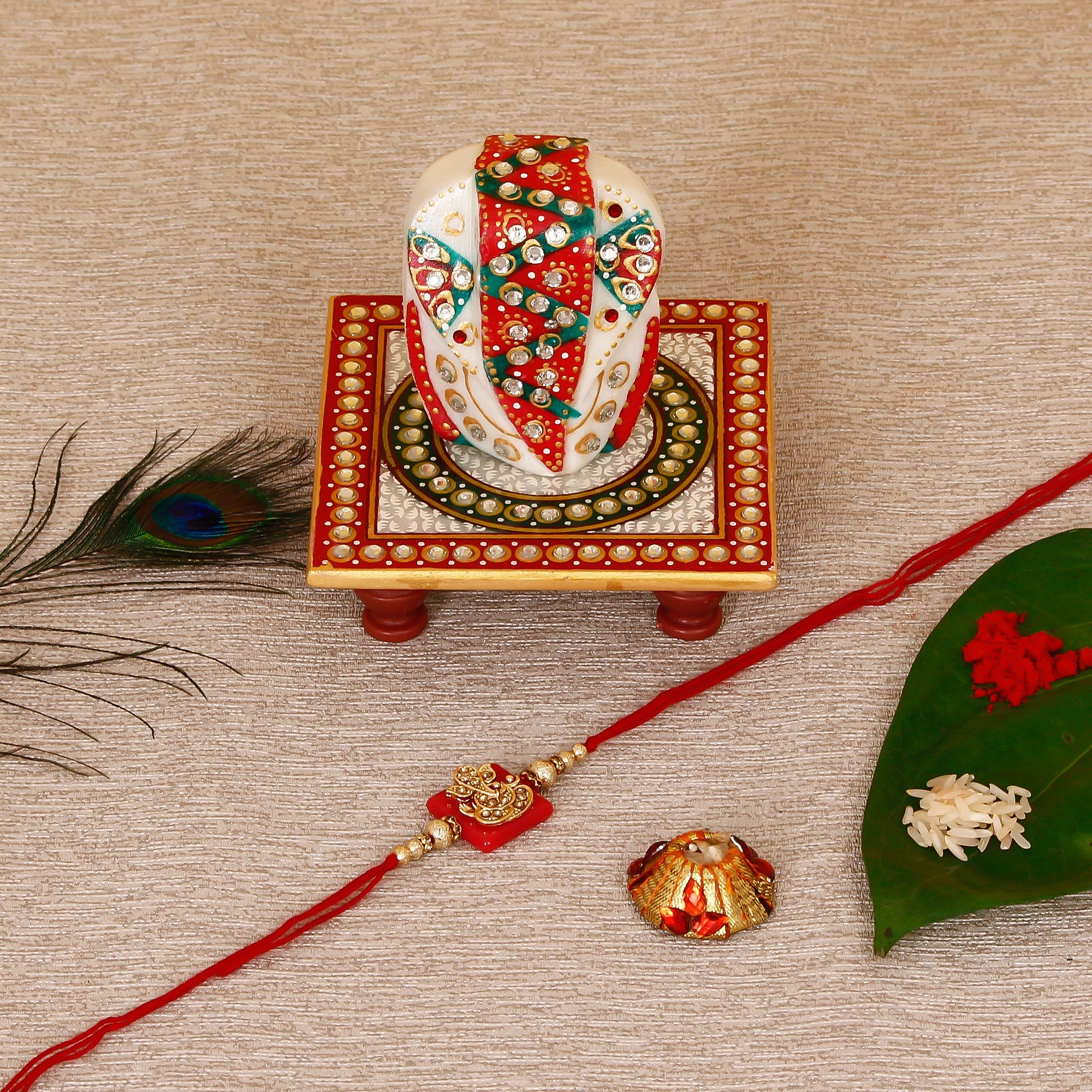 Designer Religious Ganesha Rakhi with Lord Ganesha on Kundan Studded Marble Chowki and Roli Tikka Matki Kafalo