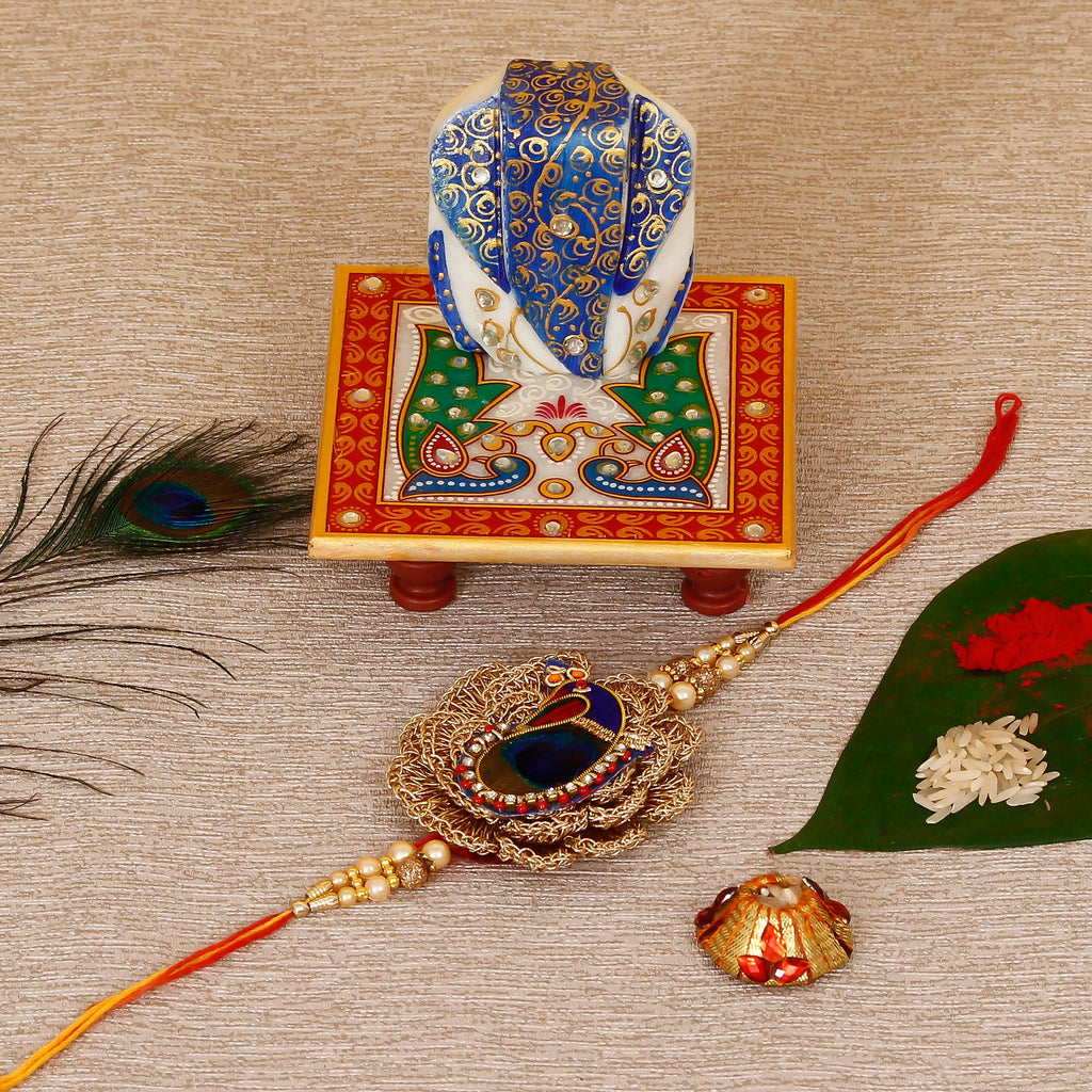 Designer Peacock Rakhi with Lord Ganesha on Marble Chowki and Roli Tikka Matki Kafalo