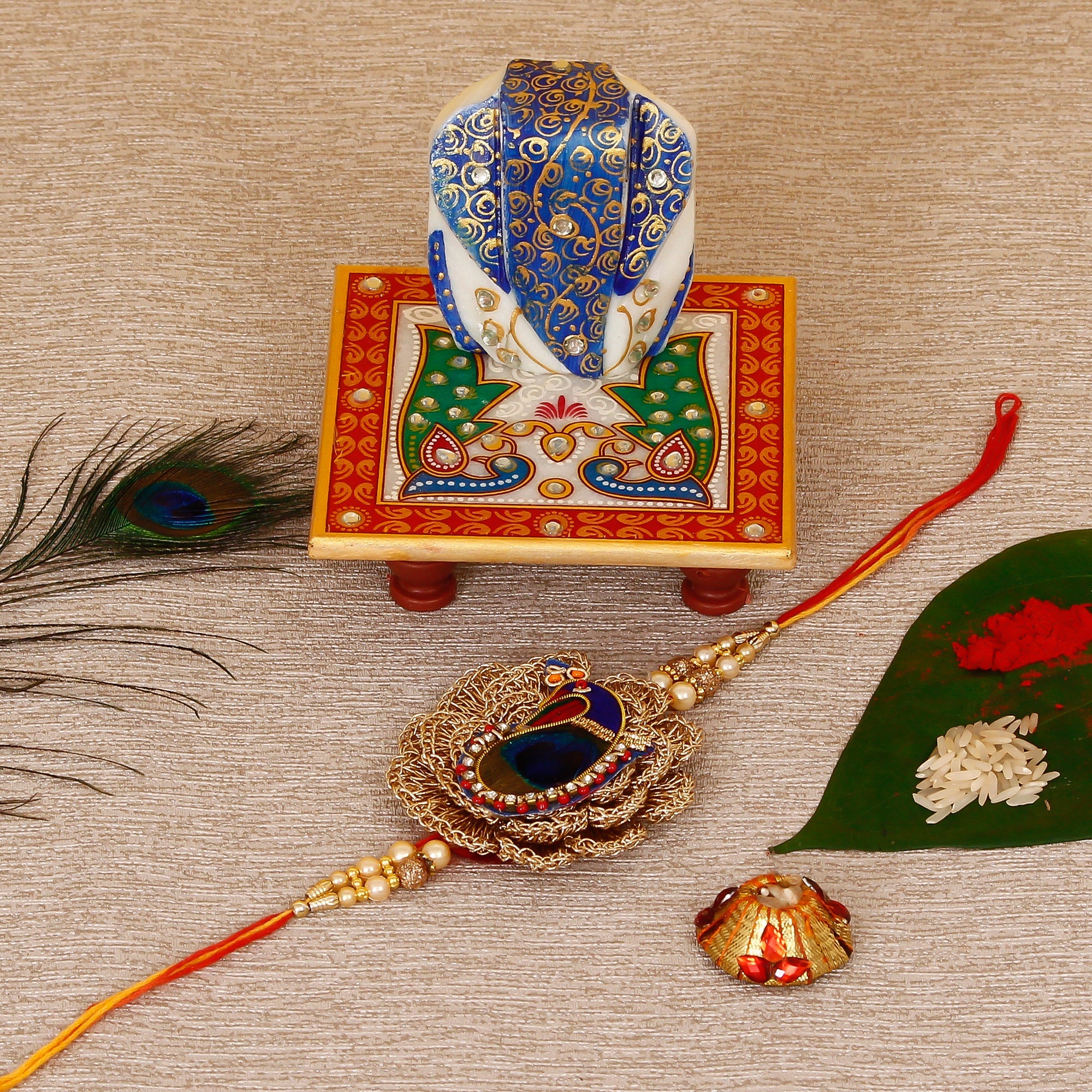 Designer Peacock Rakhi with Lord Ganesha on Marble Chowki and Roli Tikka Matki Kafalo