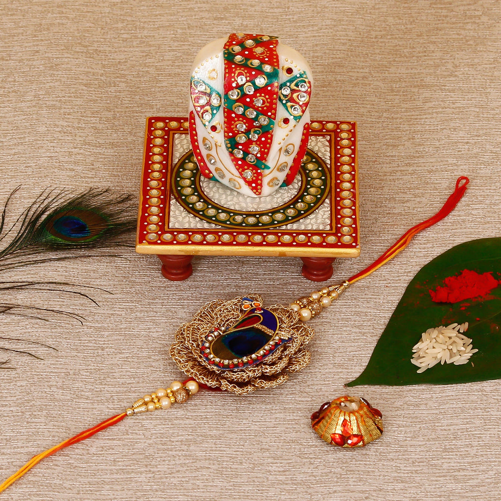 Designer Peacock Rakhi with Lord Ganesha on Kundan Studded Marble Chowki and Roli Tikka Matki Kafalo