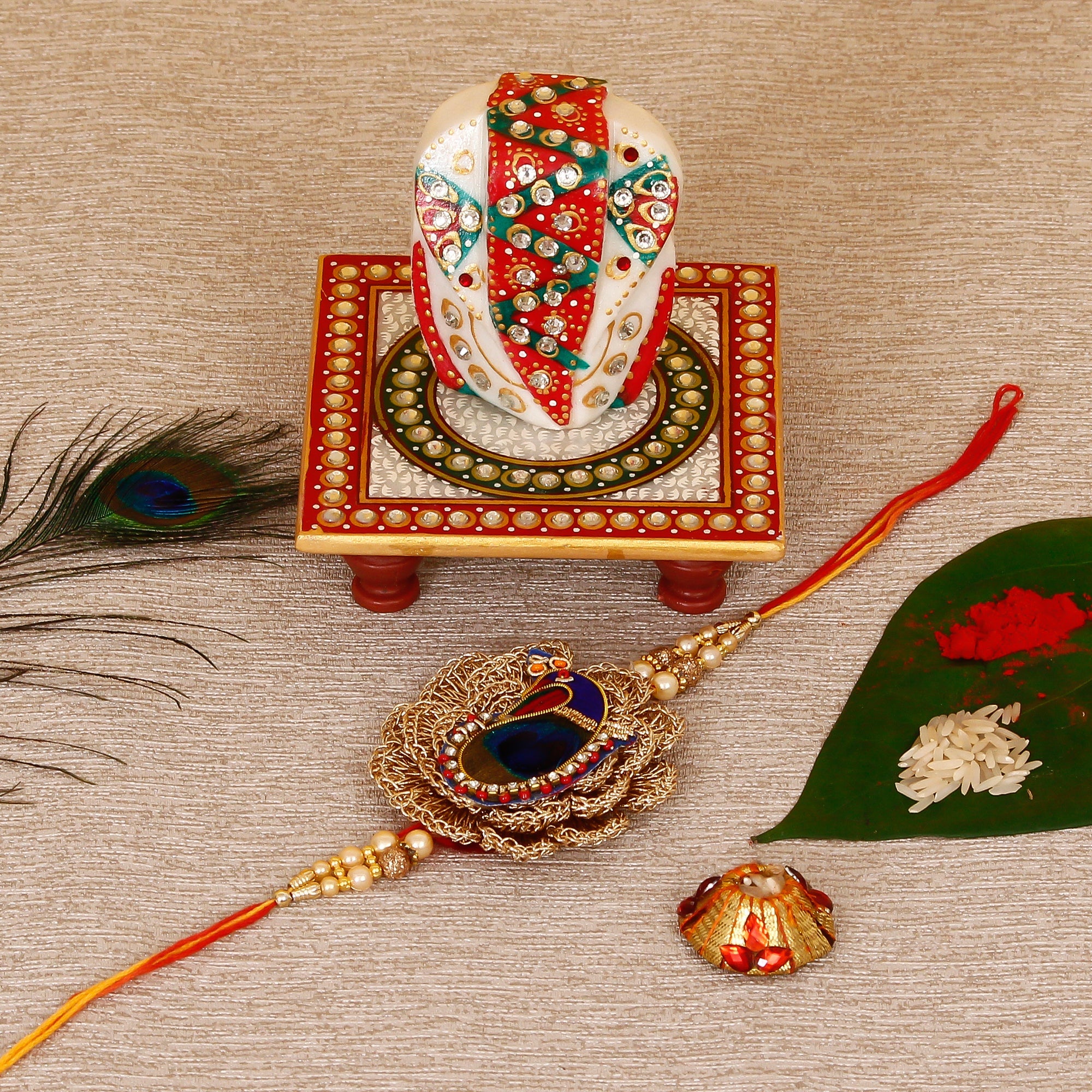 Designer Peacock Rakhi with Lord Ganesha on Kundan Studded Marble Chowki and Roli Tikka Matki Kafalo