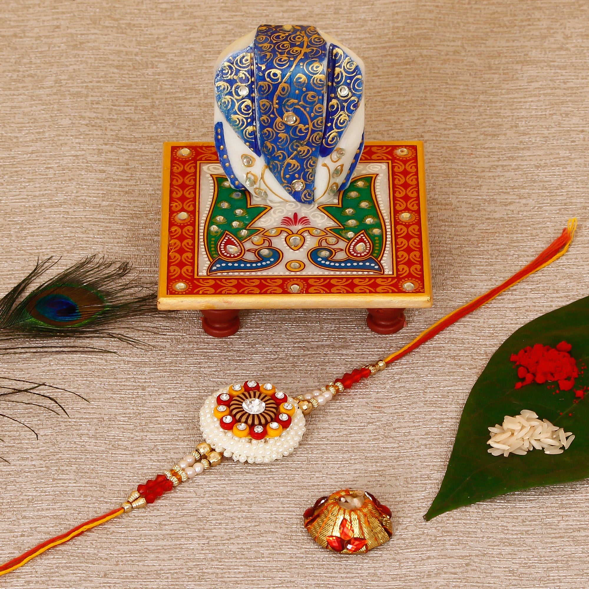 Designer Rakhi with Lord Ganesha on Marble Chowki and Roli Tikka Matki Kafalo