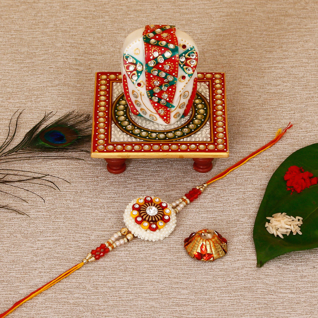 Designer Rakhi with Lord Ganesha on Kundan Studded Marble Chowki and Roli Tikka Matki Kafalo