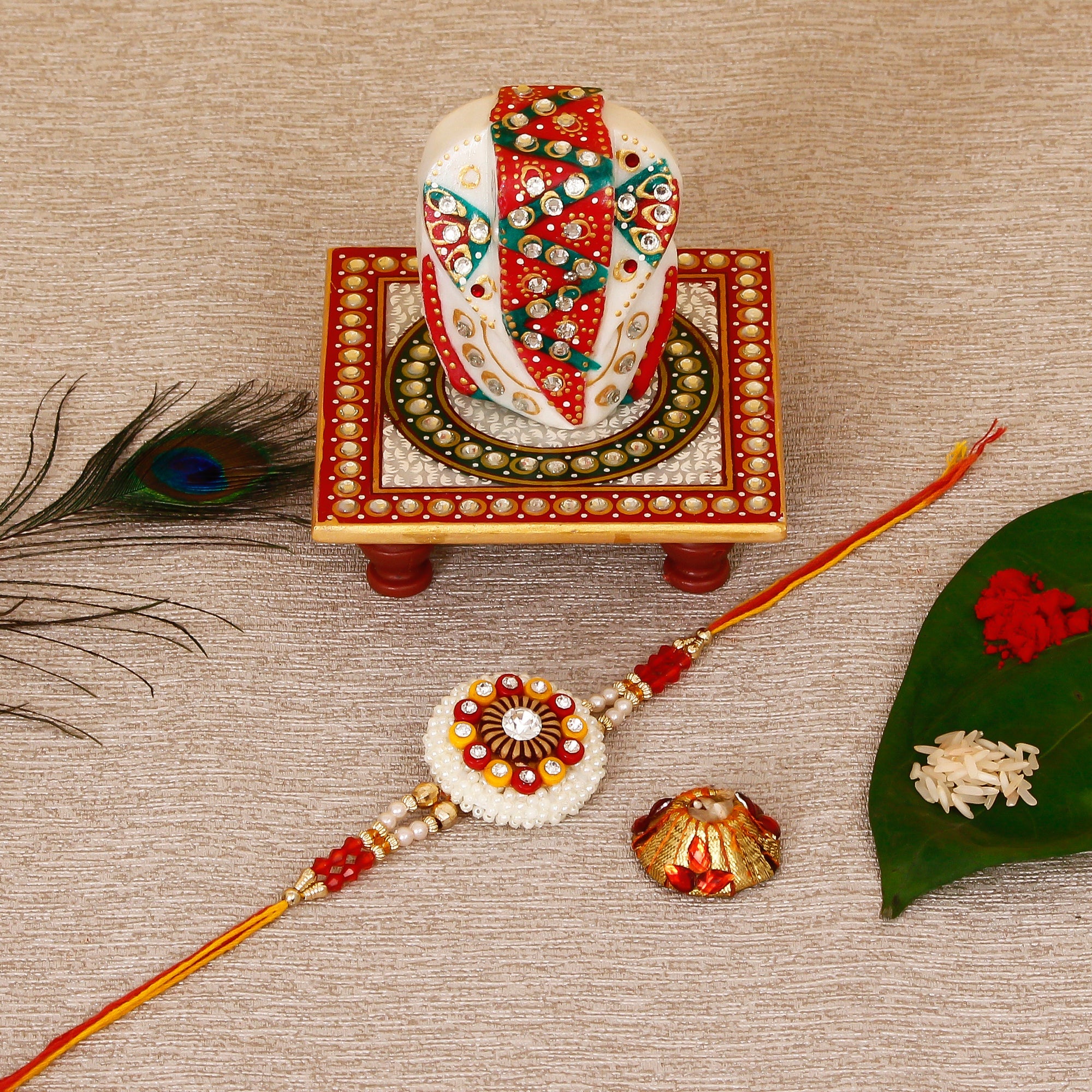 Designer Rakhi with Lord Ganesha on Kundan Studded Marble Chowki and Roli Tikka Matki Kafalo