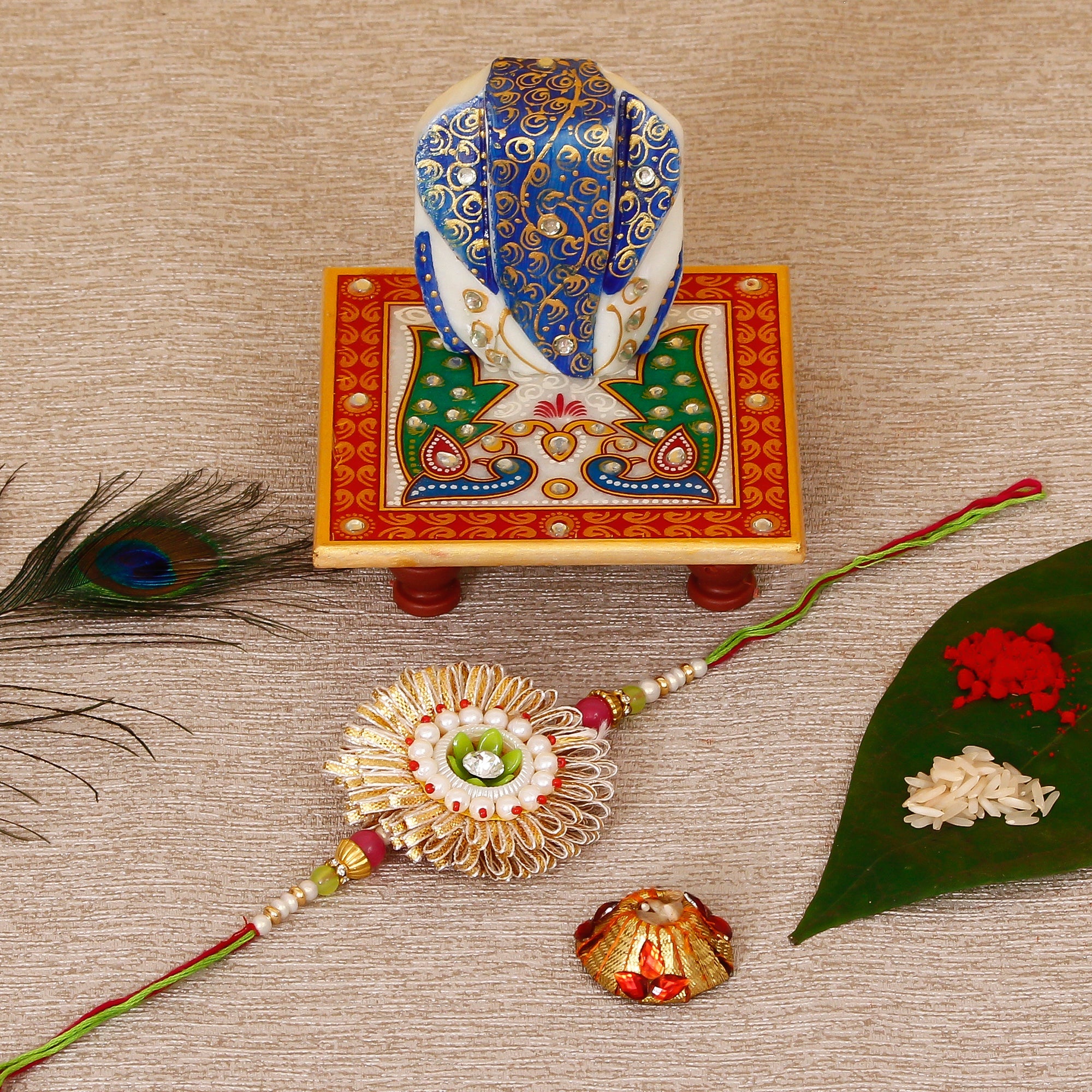 Designer Rakhi with Lord Ganesha on Marble Chowki and Roli Tikka Matki Kafalo