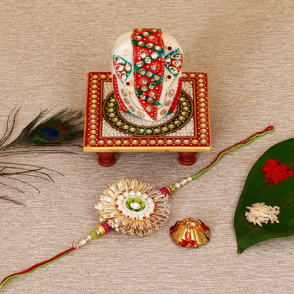 Designer Rakhi with Lord Ganesha on Kundan Studded Marble Chowki and Roli Tikka Matki Kafalo