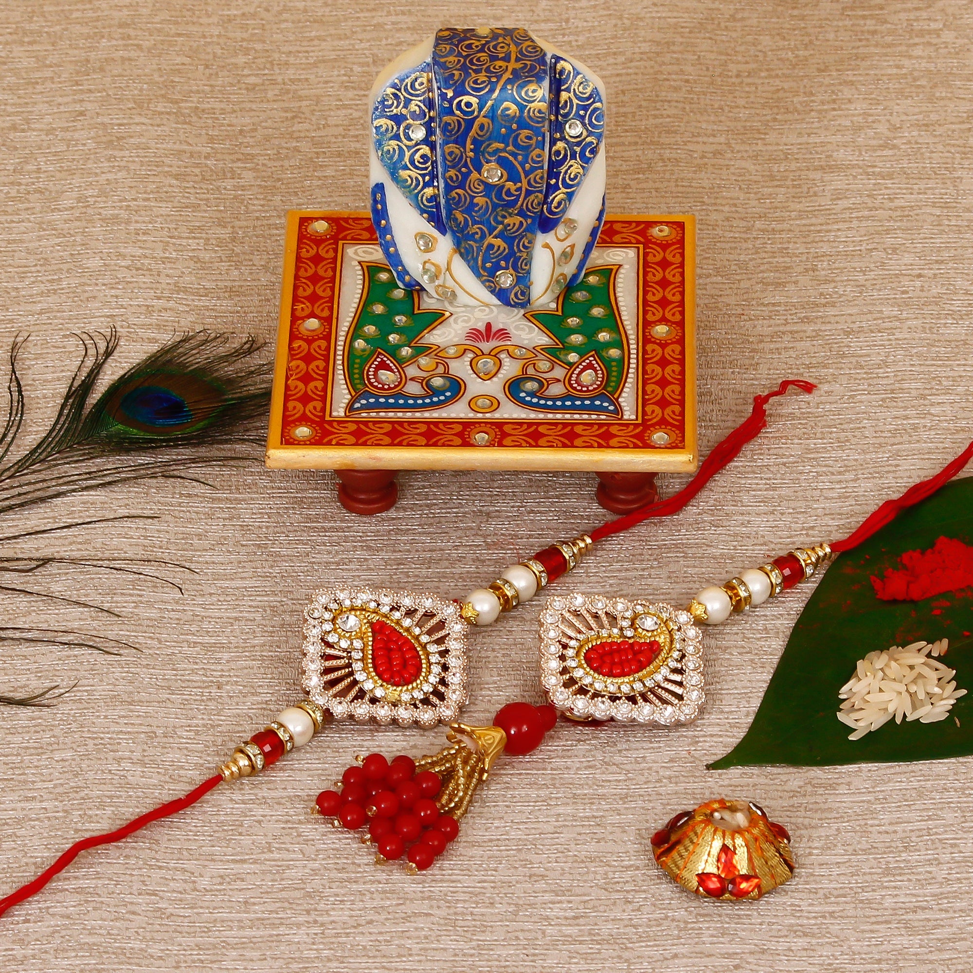 Designer Bhaiya Bhabhi Rakhi with Lord Ganesha on Marble Chowki and Roli Tikka Matki Kafalo