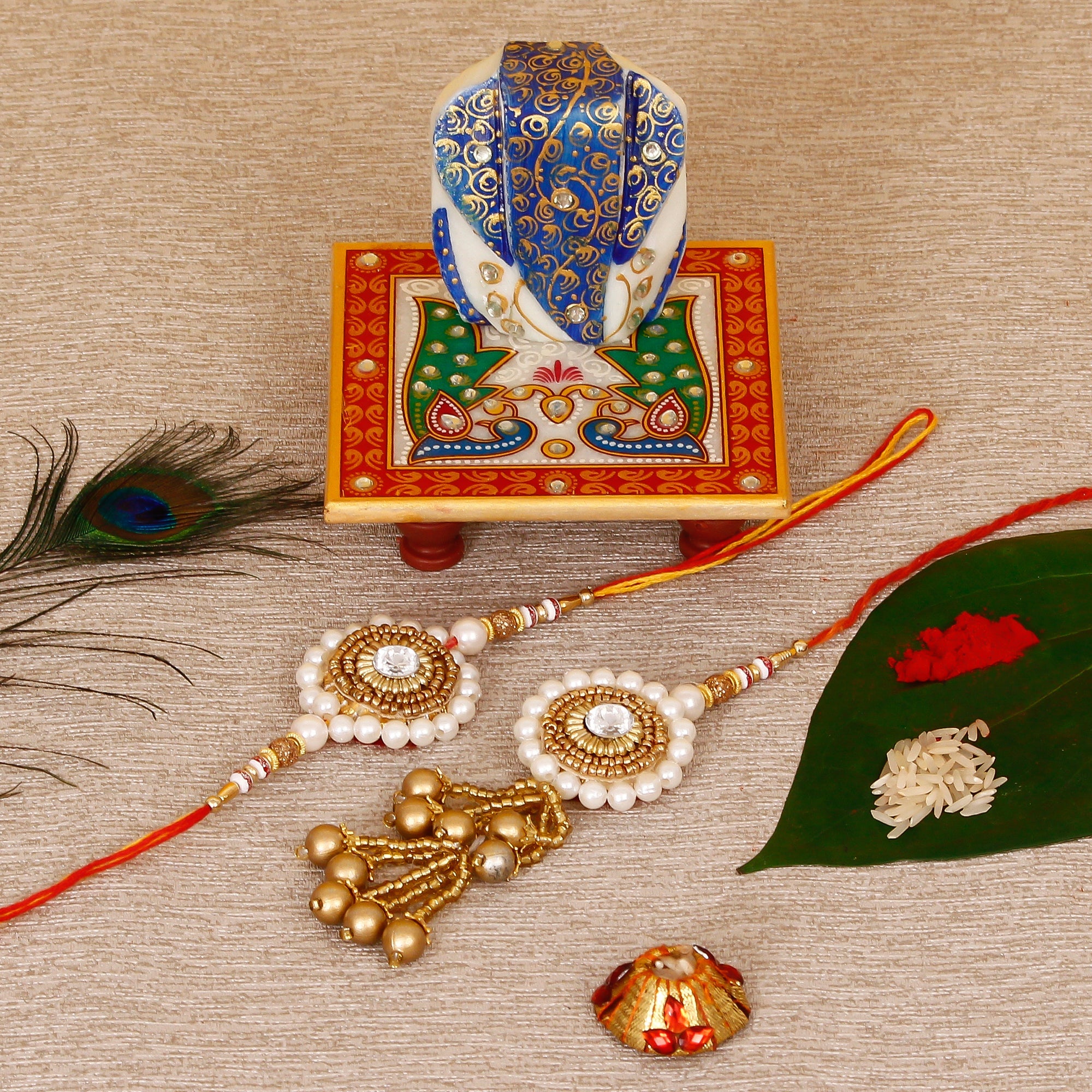 Designer Bhaiya Bhabhi Rakhi with Lord Ganesha on Marble Chowki and Roli Tikka Matki Kafalo