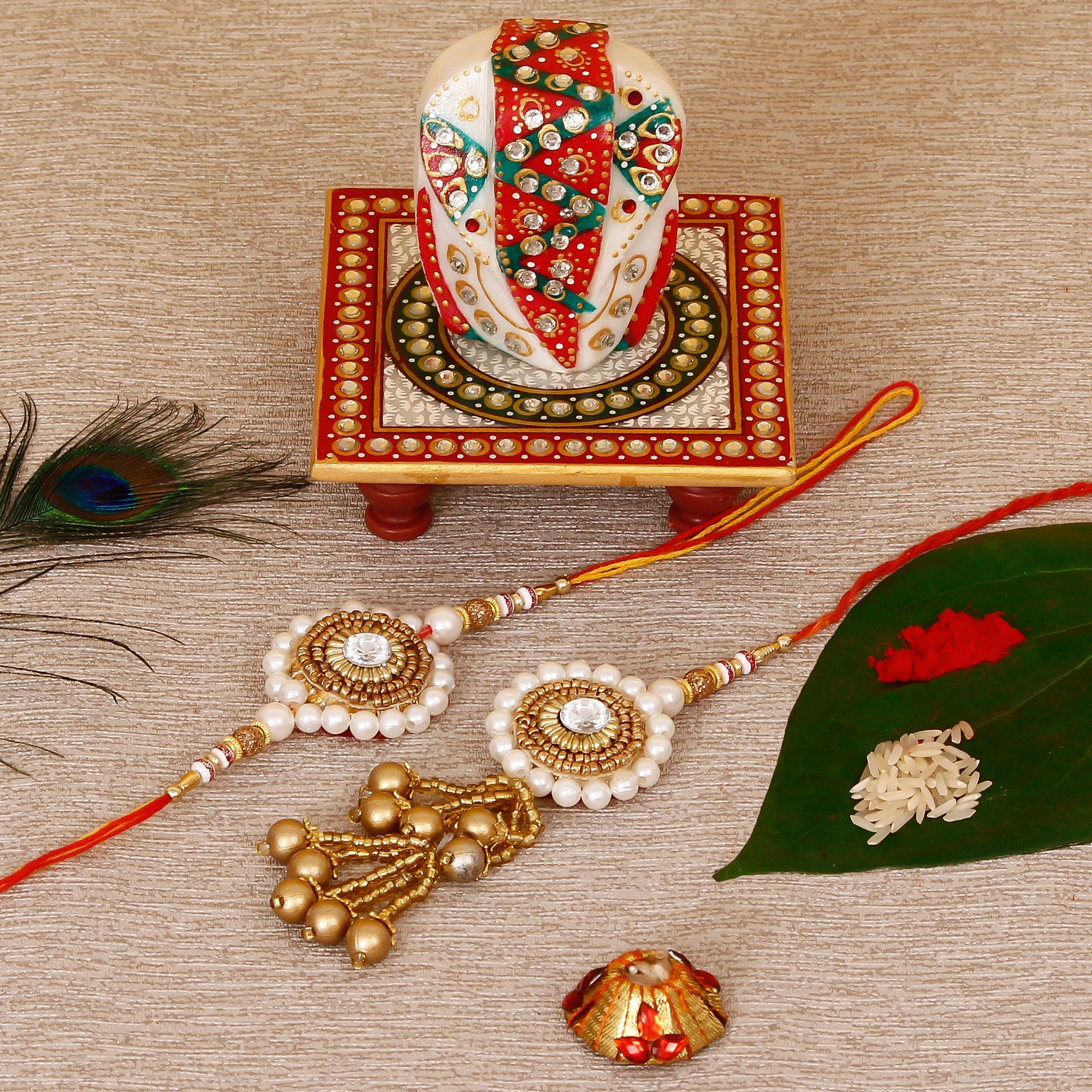 Designer Bhaiya Bhabhi Rakhi with Lord Ganesha on Kundan Studded Marble Chowki and Roli Tikka Matki Kafalo