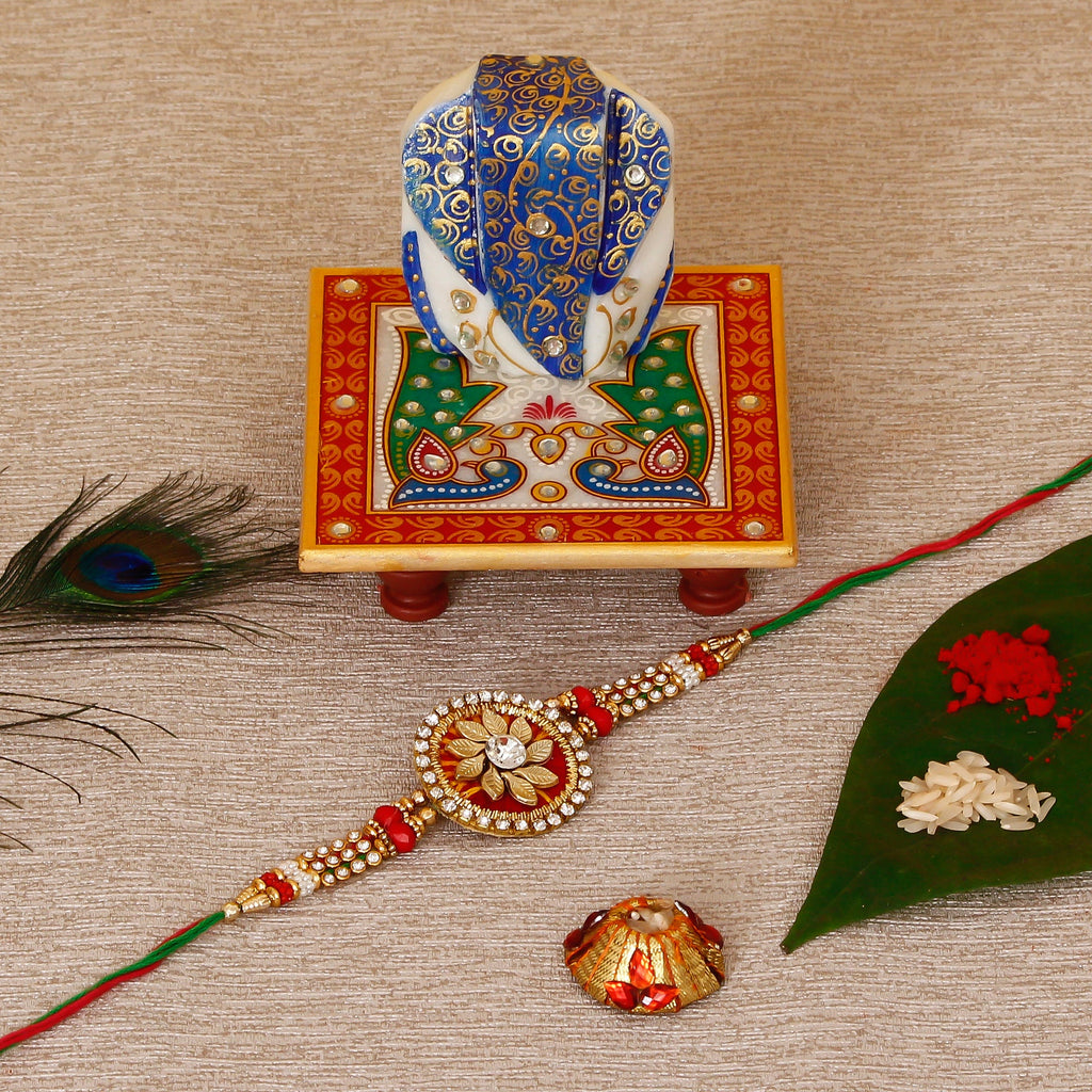 Designer Rakhi with Lord Ganesha on Marble Chowki and Roli Tikka Matki Kafalo