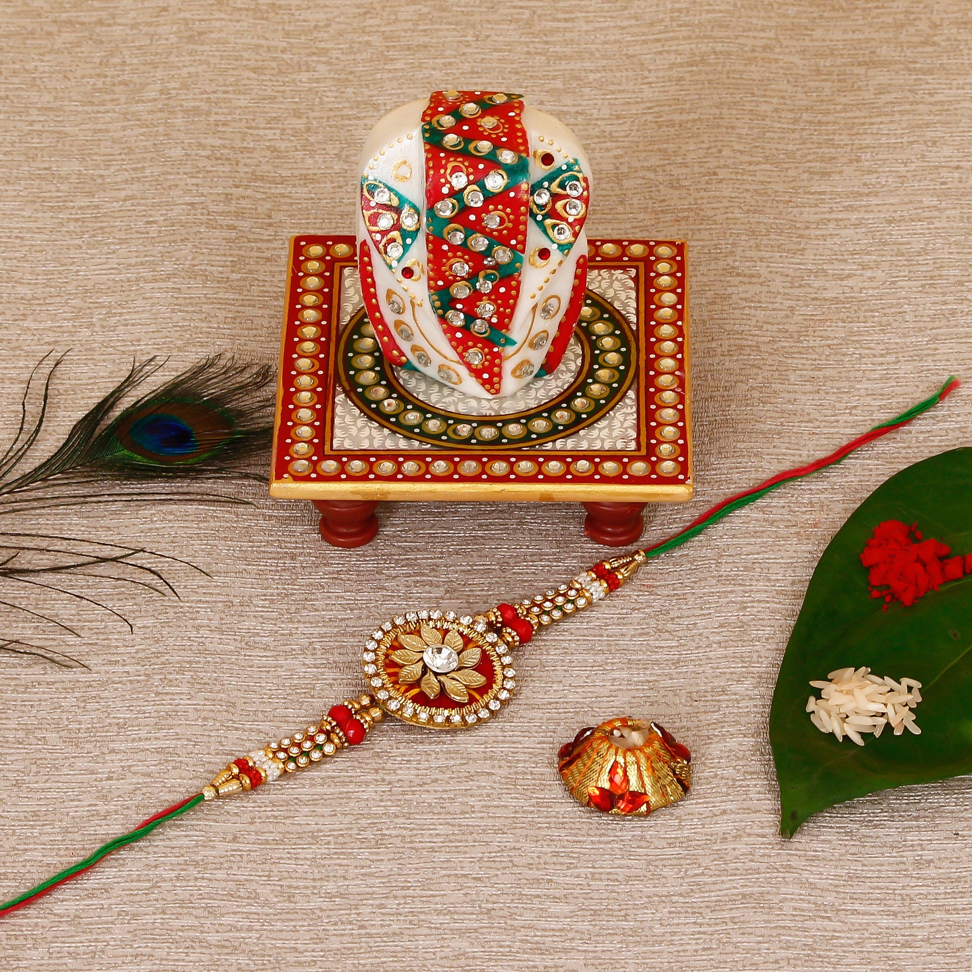 Designer Rakhi with Lord Ganesha on Kundan Studded Marble Chowki and Roli Tikka Matki Kafalo