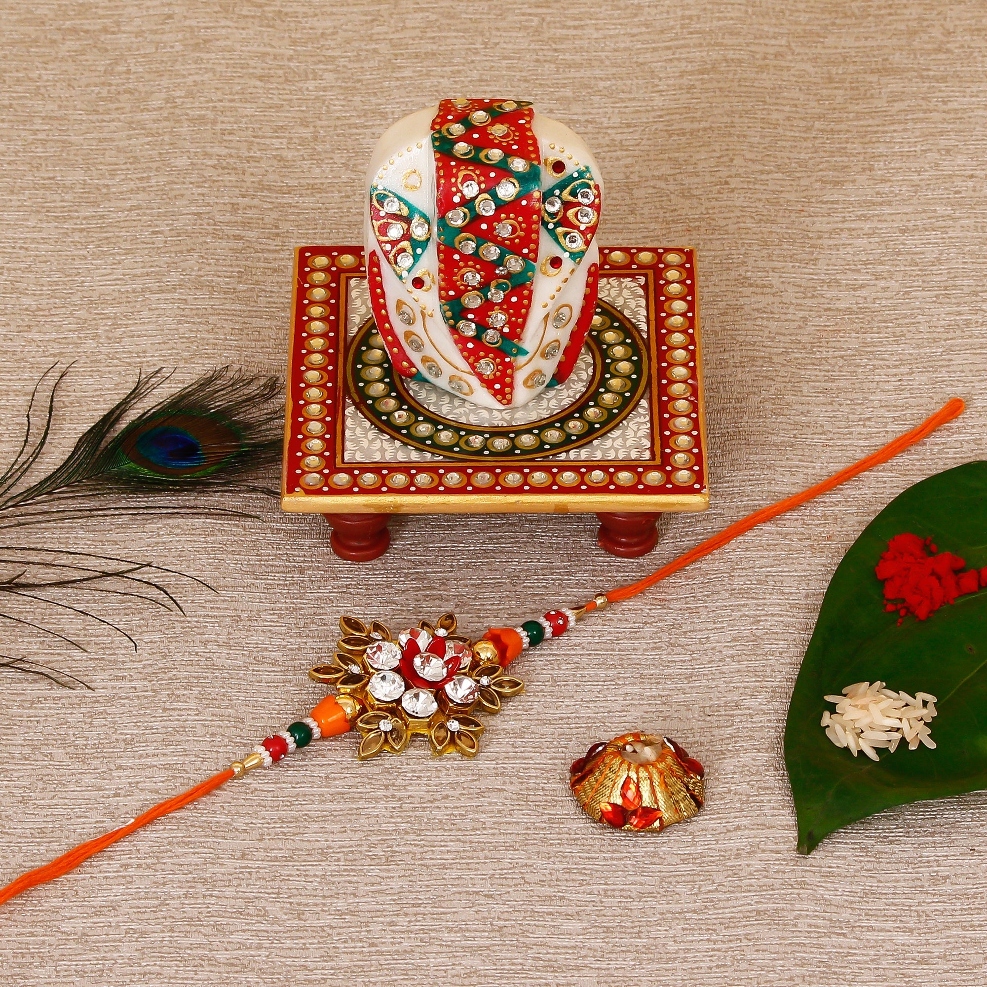 Designer Rakhi with Lord Ganesha on Kundan Studded Marble Chowki and Roli Tikka Matki Kafalo