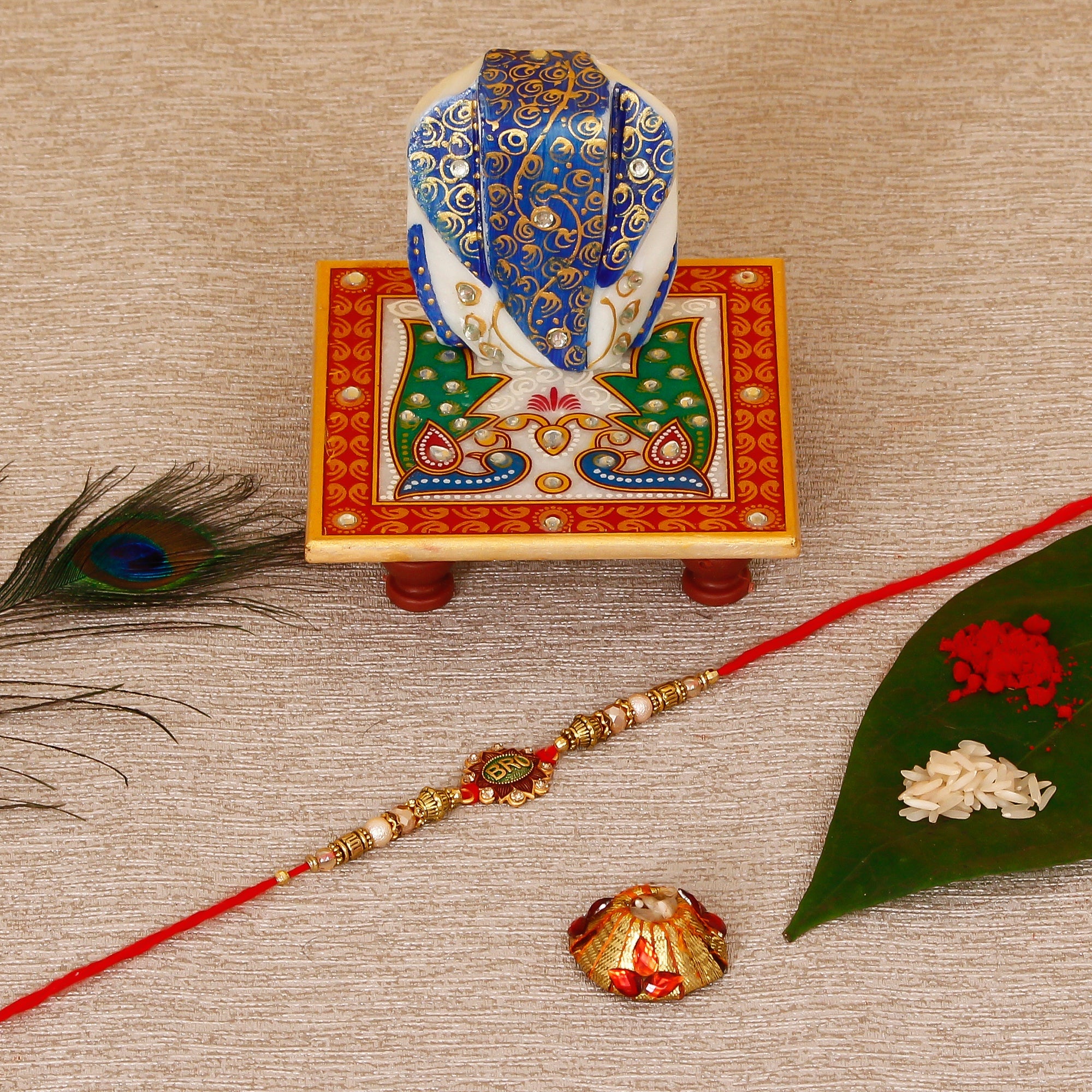 Designer Rakhi with Lord Ganesha on Marble Chowki and Roli Tikka Matki Kafalo