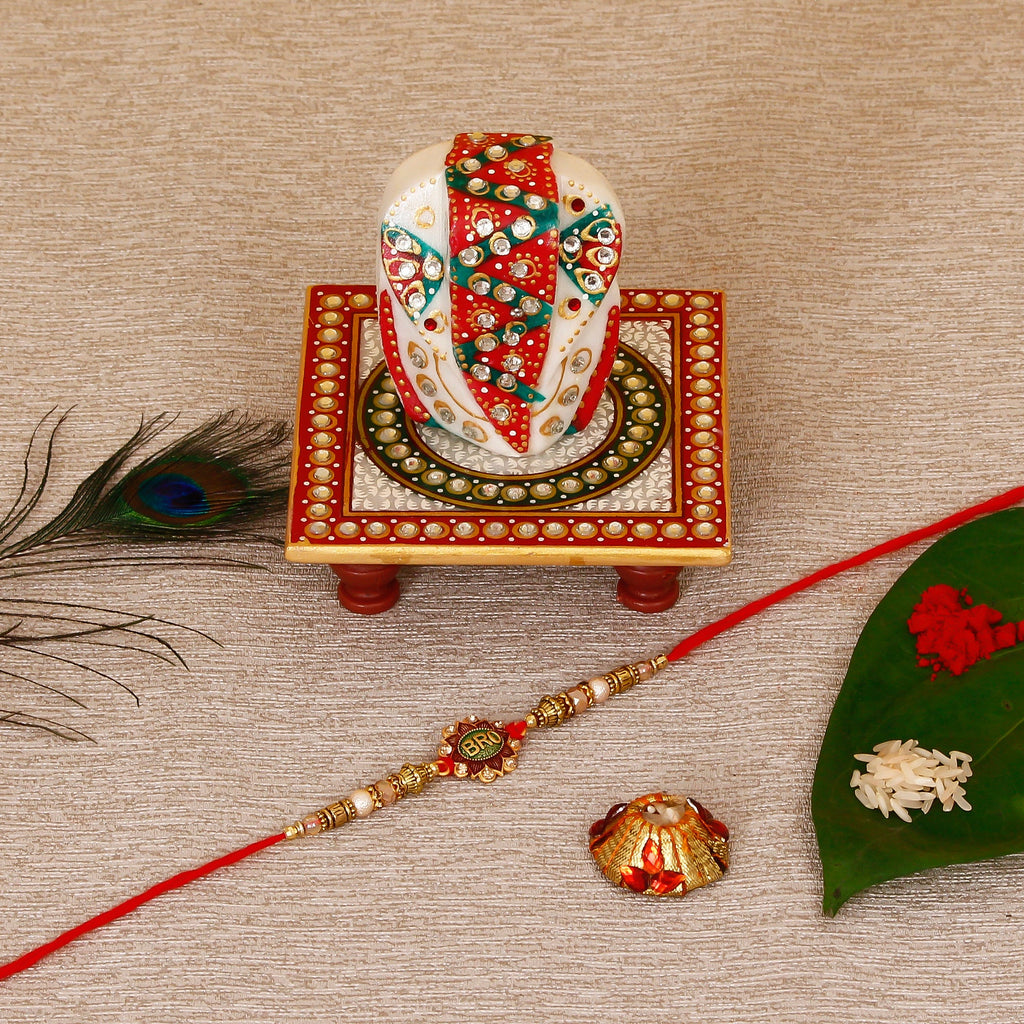 Designer Rakhi with Lord Ganesha on Kundan Studded Marble Chowki and Roli Tikka Matki Kafalo