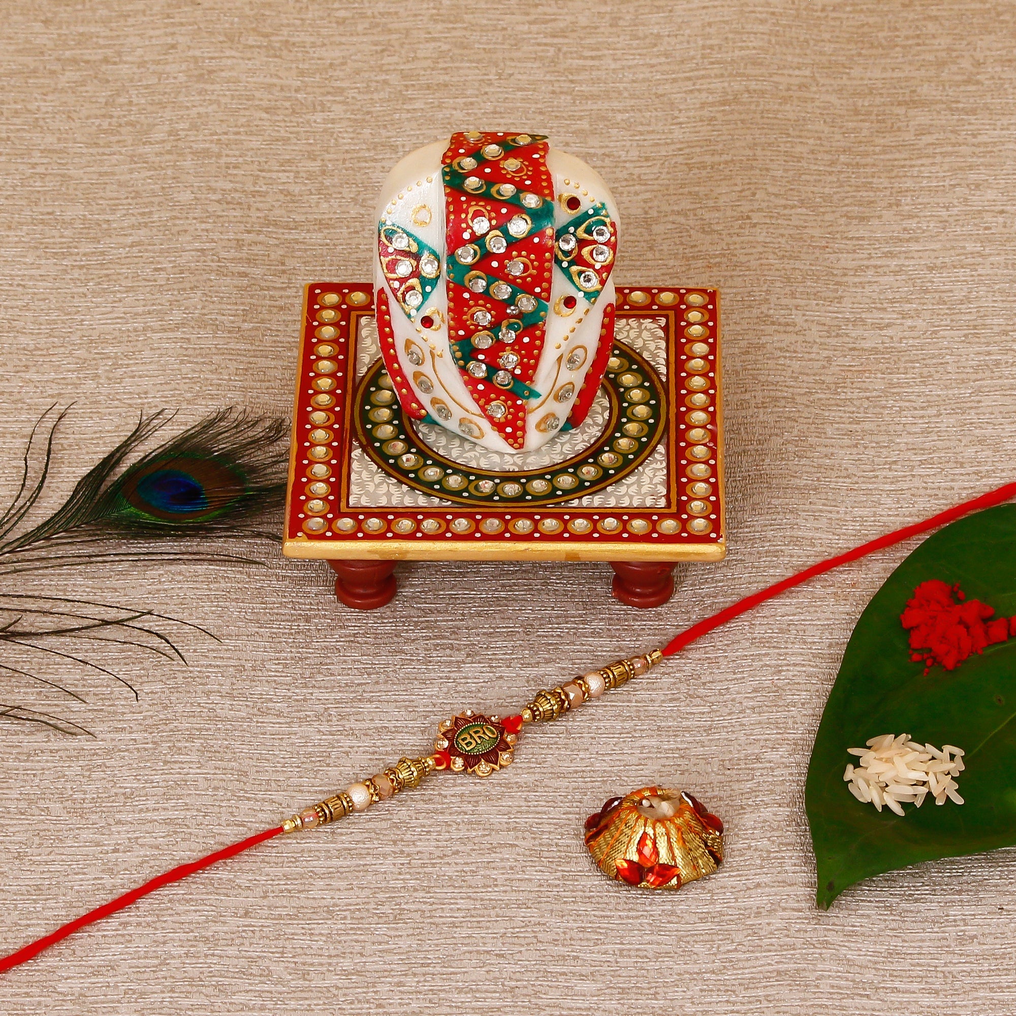 Designer Rakhi with Lord Ganesha on Kundan Studded Marble Chowki and Roli Tikka Matki Kafalo